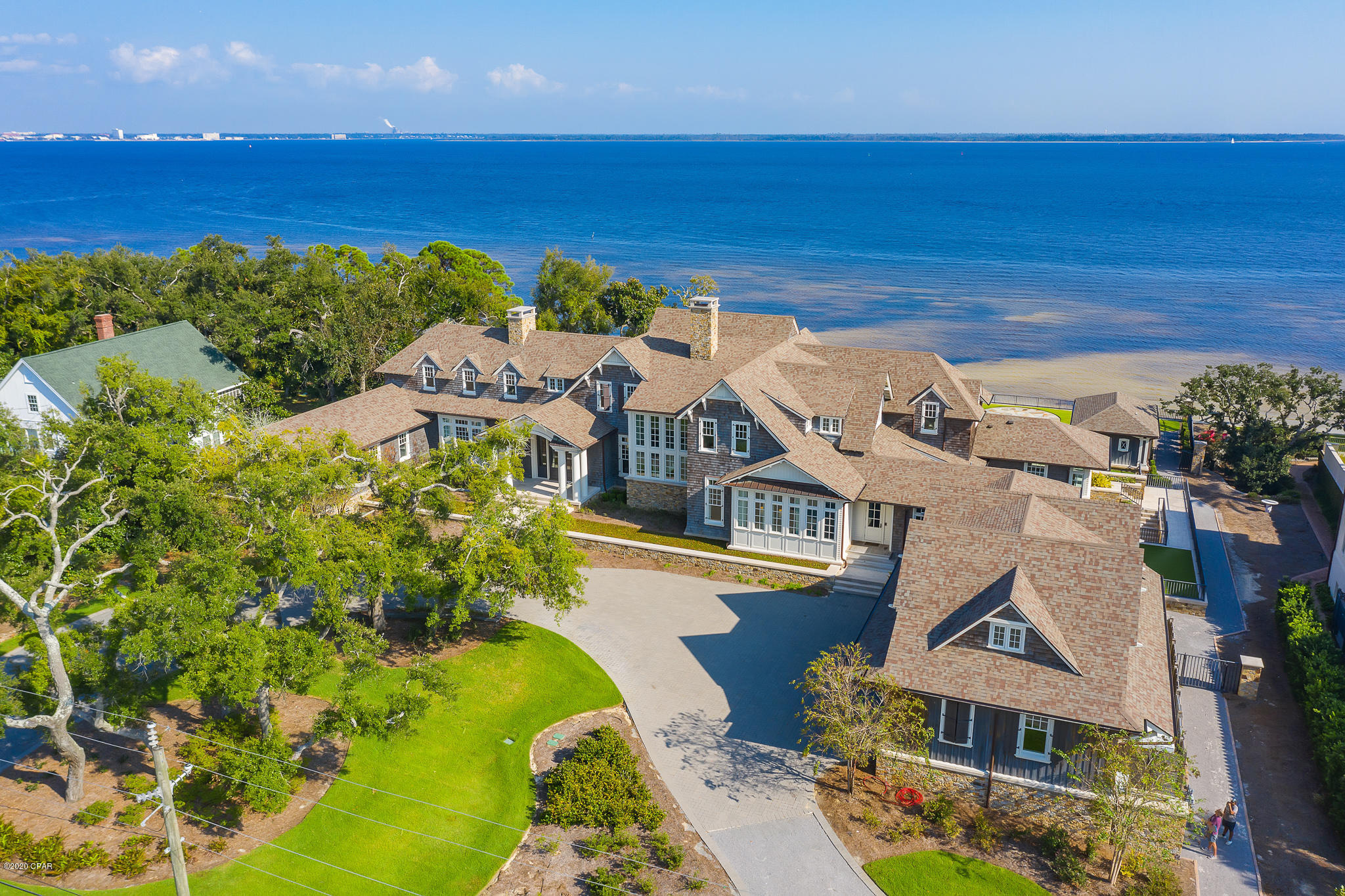 Reigning over 3.1 acres, this impressive Hamptons style edifice sprawls along 200+ feet of Bay frontage framed by both the historic St. Andrews Bay and the lush picturesque vegetation present throughout the estate. A true architectural masterpiece executed by the sought-after architect Eric Watson and builder Clifford C. Myers of Macintosh Myers Construction. The optimal balance of both common and intimate areas is achieved in the 21,000 square feet of highly articulated living space spanning three cohesive levels interconnected by both grand staircases and elevator. The estate is geographically poised within close proximity to the famed Shell Island and Gulf of Mexico pass by boat along with the world-class dining. The kitchen is a chef's dream featuring custom cabinetry hand crafted by Morgan Creek, marble countertops, and separate serving pantry. The backyard is synonymous with relaxation; take a dip in the saltwater infinity pool overlooking the Bay or catch a tan on the private white sand beach with room to add a 150'+ dock. The one-acre parcel to the West of the main home is an extenuation of the estate providing additional parking and storage in addition to a four-car garage with workshop and fully equipped kitchen. Notable accommodations include a private helicopter pad, seven-car garage, geothermal heating and cooling system, whole home automation system, state of the art theatre room, commercial grade generator, and a safe room with dedicated communications. Inquire today to schedule a private viewing.