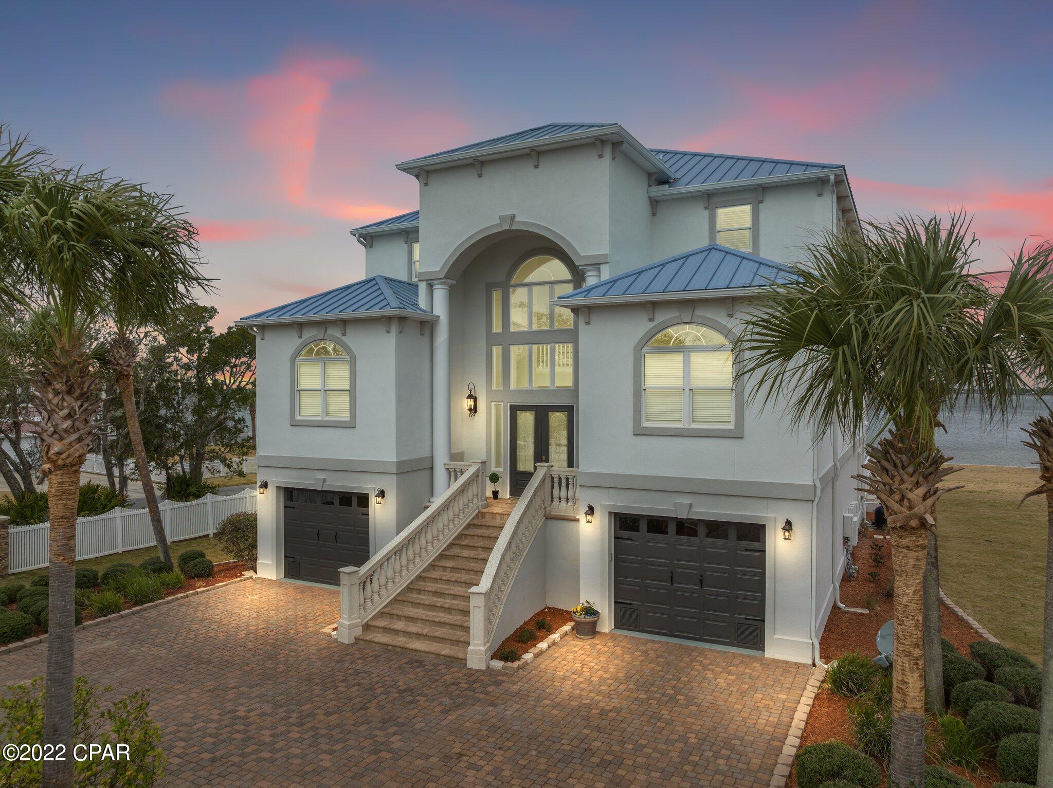 This magnificent one-of-a-kind custom beautiful bay front home is at the end of a quiet road in Lynn Haven! This home has it ALL!  The 1st floor includes a spacious living room with a kitchen and an oversized room.  The 2nd floor features an elegant hardwood living room, formal dining area with decorative columns, spacious kitchen with stainless appliances. The kitchen has a beautiful Taj Mahal quartzite counter top, spacious island, a smooth surface cook top, custom cabinets and a decorative back splash. The kitchen and living room have a remarkable bay view from almost every angle. The additional bedrooms on the second floor all have spacious closets and hardwood floors. The 3rd floor is the master suite with no detail left behind. The split suite has an endless opportunity for a nice sitting area to read, an office or work out area overlooking the bay.   This suite has a large walk-in closet, 2 vanities, a separate tub and a large shower.  Enjoy the balcony viewing the beautiful bay.  Additional interior features include, mostly hardwood flooring, crown molding, recessed lighting, elevator that services all 3 floors and in home security system.  Exterior features include, inground pool, sprinkler system, circle driveway, open patio, fully landscaped yard, boat slip with deep water access and much more.  Call today for your own private showing appointment.
