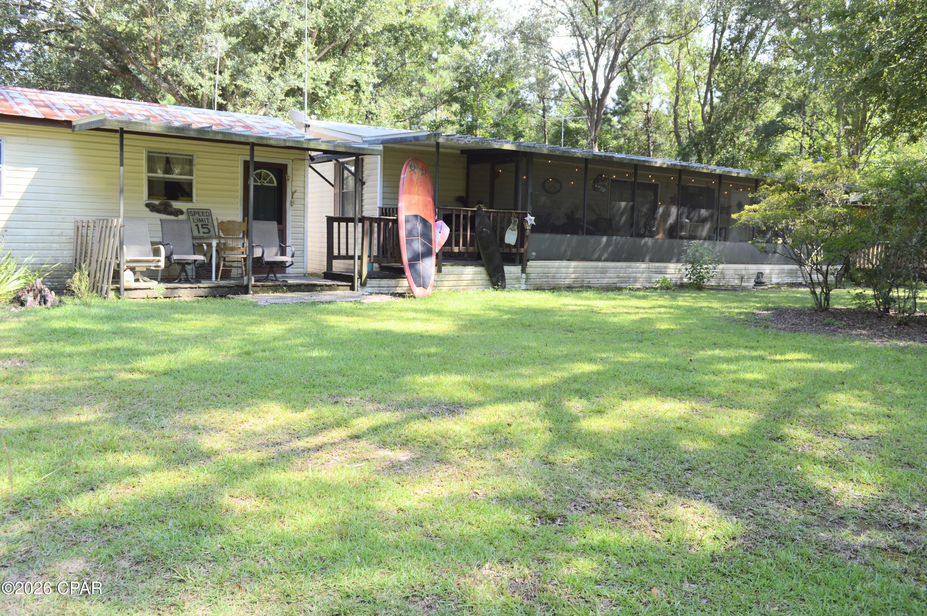 Seller is offering $5000 in closing cost assistance with acceptable offer. Come and see what this charming 3-bedroom, 2-bath home offers with it's 1,152 sq ft of comfortable living on a fully fenced and cross-fenced 2-acre property just minutes from Holmes Creek and Culpepper Landing. From the landing, enjoy easy access to the stunning Cypress Springs--renowned for its crystal-clear waters perfect for kayaking, diving, and swimming.

Step inside to find a welcoming layout featuring newer LVP flooring in portions of the home, a covered screened-in porch ideal for year-round relaxation, and a bright sunroom added to the back. Practical updates include a new 50-gallon water heater and a 7-year-old A/C system. The home also features a durable metal roof for low-maintenance peace of mind.

Outside, the possibilities expand. Multiple sheds, a detached garage, and an additional structure ready for use as a workshop or conversion into extra living space give you room to grow. Fruiting trees--including citrus, figs, and more--dot the property, alongside established gardening areas and a cozy fire pit. Water has already been run to multiple locations with convenient spigots, making outdoor projects and plant care simple.

Whether you're seeking a peaceful homestead, outdoor recreation at your doorstep, or space for hobbies and gardening, this property delivers. Fully fenced for privacy and security, it's ready for your next chapter.