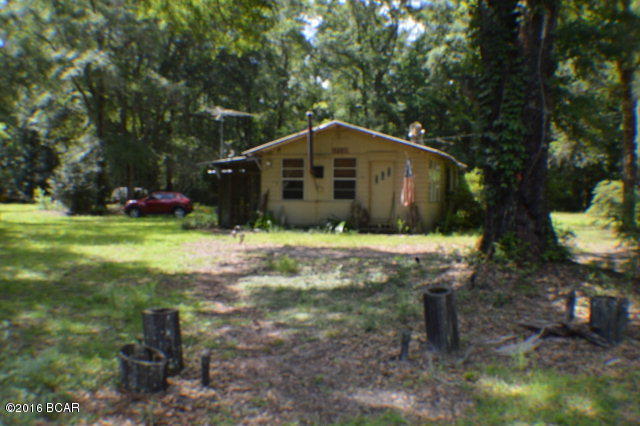 A beautiful 5 acres only 30 minutes away from Panama City Beach. Yard has always been maintained, has a small garden area, many shade trees, a grape vine, as well as a pasture area for horses or other livestock. The house is also clean n well maintained inside and out. Efficient best describes its design. An outside storage building to store mower and lawn equipment and a small dog kennel also in the yard. Great weekend get away......