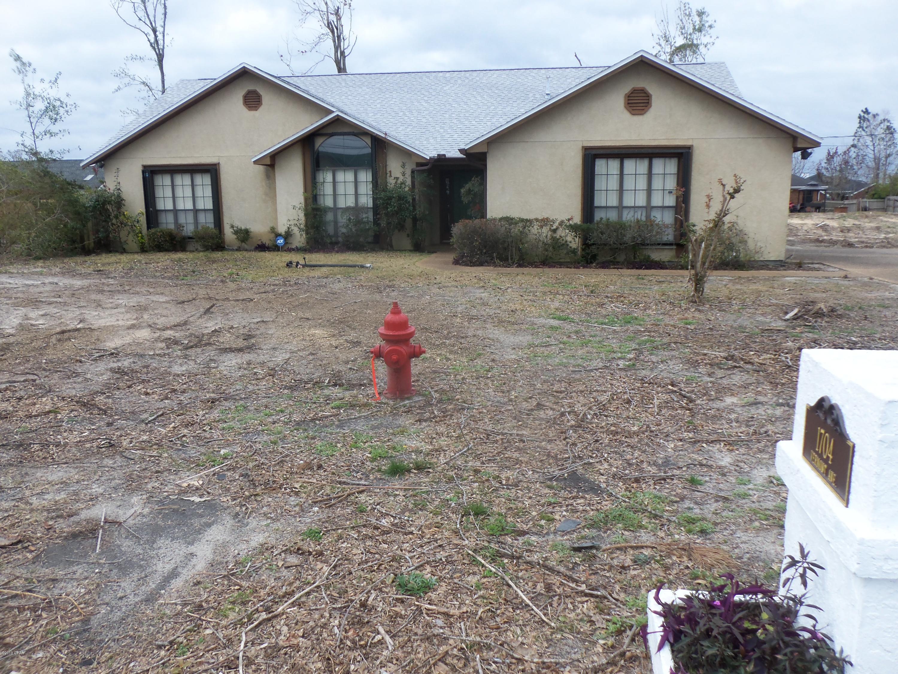 Custom one owner home on 4 (50') lots. Lot size is 2 full  typical sites (200x150'). Some mostly exterior damage due to Hurricane Michael. Elderly original owner/seller has relocated. NEW (12/2018) 30 year shingle roof  by Lynn Haven roofer. Dried in -Ready to live in now! GOOD BONES - Only needing mainly interior cosmetics...Carpet is older/soiled from age/wear. Needs paint, and updated flooring with possible kitchen/bath updates - but livable NOW as is. BIG (9x36) HUGE SCREEN ENCLOSED PORCH w/L-shape (7x10) . SELLING AS IS. Security and sprinkler systems both may need activation. Gas Fireplace, Vaulted Ceilings with open Living/Dining & Kitchen/Breakfast areas. Laundry off Kitchen. Contemporary floor plan & ''Move in Ready'' with just  freshening up and minor work. RV/boat parking pad.