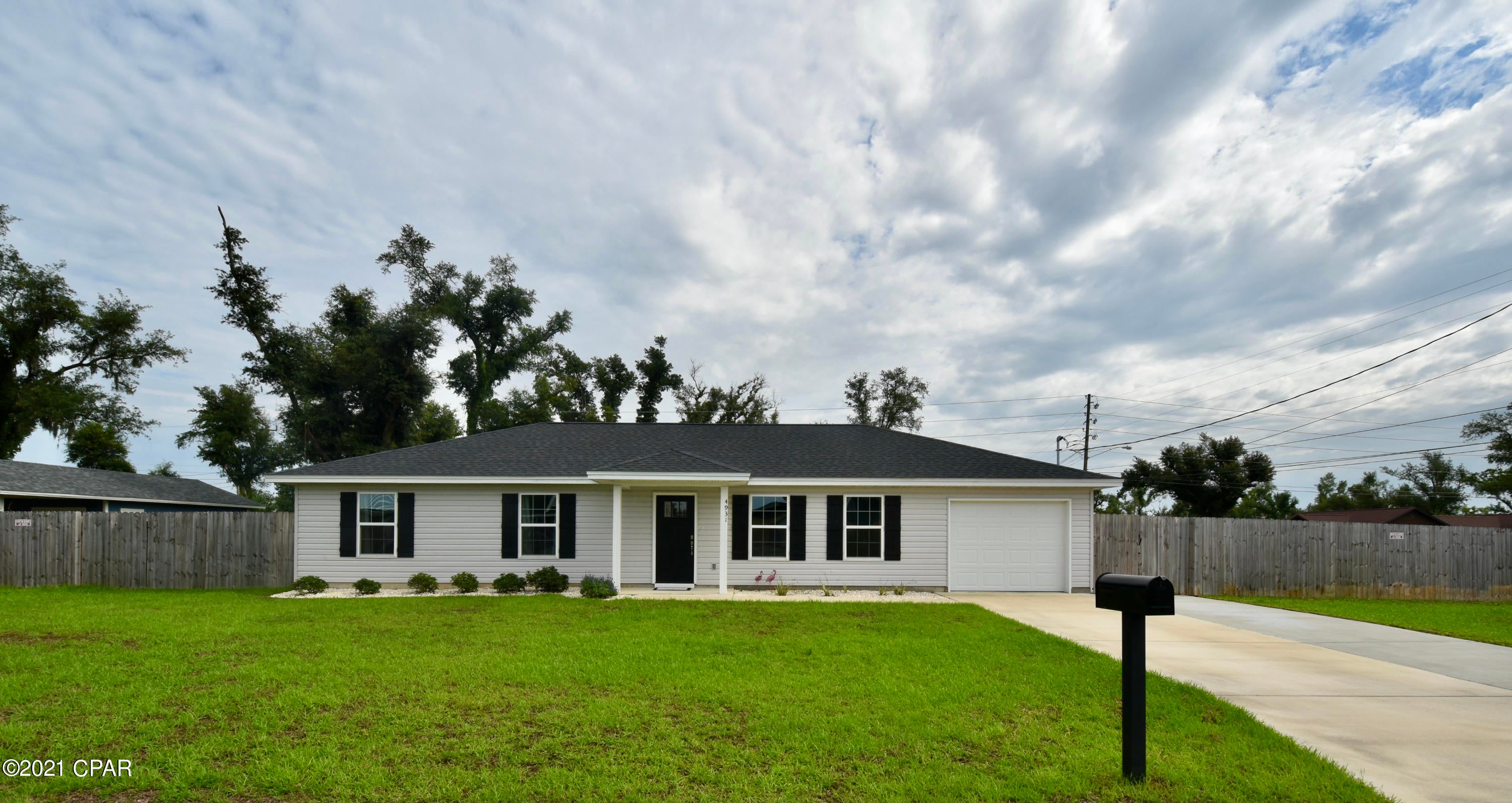 Beautiful well appointed home minutes to Tyndall AFB! One owner 3 bed/2 bath, over 1/4 acre, and fenced for privacy.  This home exhibits its natural flair with a spacious greatroom and kitchen area w/pantry. This 1,402 sq ft home offers open concept living with kitchen island, stainless steel appliances, and highlighted by tray ceilings in dining and living room.  The master suite includes a shower/tub combo and walk-in closet. The privacy fence provides safety and security for your children or pets, while the covered porch offers plenty of space to relax, grill, and unwind! This beautiful, well kept home is ready for your family today! Call for your private tour! Measurements/sizes are approximate; verify if important.