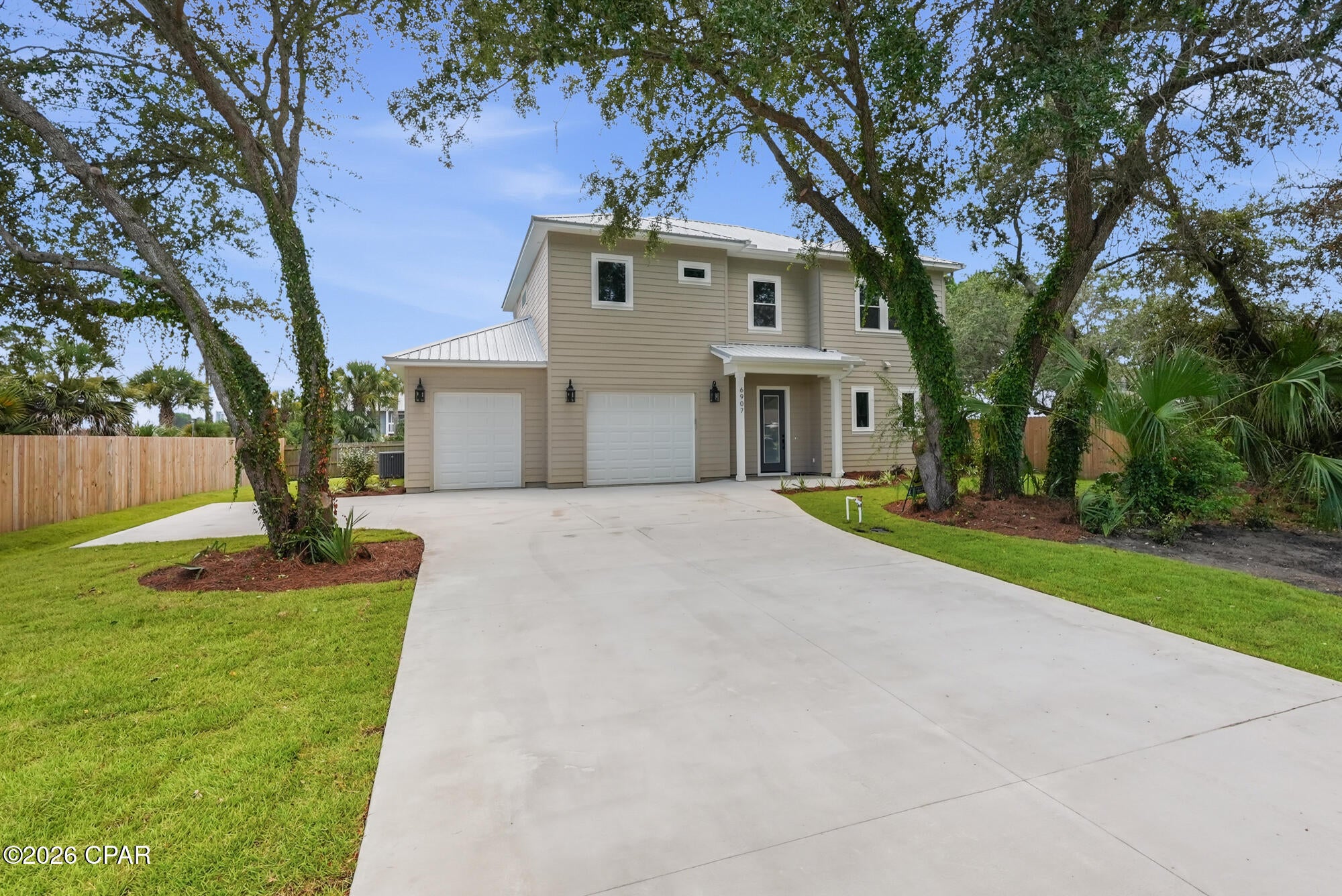 Welcome to your ultimate COASTAL RETREAT with views of GRAND LAGOON! This stunning, new construction Coastal Craftsman masterpiece perfectly combines modern elegance with the relaxed Panama City Beach lifestyle. Step inside to discover a bright, sun-drenched sanctuary defined by soaring 10-foot ceilings, loads of windows, and  glass doors designed to seamlessly bring the outside in. The gourmet kitchen is a chef's dream, beautifully appointed with premium Quartz countertops, stylish designer lighting, contemporary hardware and a custom RANGE HOOD.  Engineered for the active coastal lifestyle, this property features an oversized garage plus a separate, dedicated parking space to easily store your boat, golf cart, and all your outdoor toys. Enjoy total freedom and unbeatable peace of mind with durable, low-maintenance Hardie board siding, low insurance costs, no required flood insurance, and no HOA fees. Located in a premier golf-cart-friendly community, you are just moments from a public boat launch, top-rated local restaurants, and the pristine shores of St. Andrews State Park. Whether you are looking for a private beachside sanctuary or a high-yielding Short-Term Rental (STR) investment, this turnkey property hits every mark. Schedule your tour today and start living the coastal dream!