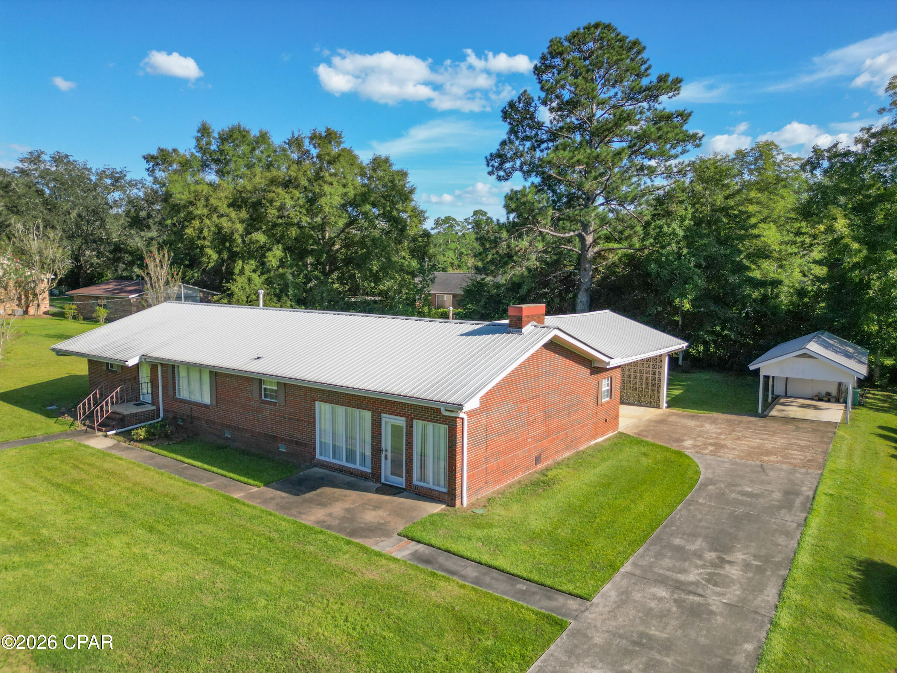 Welcome to this spacious 3-bedroom, 3-bath brick home situated on a beautiful half-acre lot in Graceville, just minutes from The Baptist University of Florida. With generous living spaces, a flexible floor plan, and handicap-accessible features, this home has plenty to offer!

Step inside to a large 20' x 17' living room featuring impressive 10-foot ceilings and a cozy wood-burning fireplace. An adjacent office provides a great space for working from home and includes its own bathroom, including the primary suite, with a large laundry room conveniently located nearby.

A few steps up lead into the kitchen and dining area, where French doors open to the back porch and carport area, making it easy to enjoy the spacious backyard. The home also features a large formal living room, providing even more room for entertaining, relaxing, or creating a space that fits your needs.

Two of the bedrooms have convenient access to their own bathrooms, including the primary suite, which features a beautiful tiled shower designed with handicap accessibility in mind, and flooring throughout the home includes a mixture of carpet, ceramic tile, and wood-look tile. Additional features include a durable metal roof, a 2022 HVAC system, and city water and sewer.

Outside, the beautiful half-acre yard offers plenty of room to enjoy the outdoors while still being conveniently located near the heart of Graceville. With its solid brick construction, spacious layout, accessibility features, and convenient location near the college, this home is ready for its next owner!