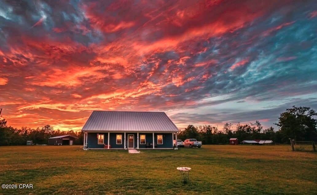 13.75 acres • 6 BR / 3 BA • 2,612 heated SF • 10 fenced acres • 2 RV hookups • Electric pole barn • Tractor & implements included • No HOA

Set on 13.75 acres in Clarksville, 11674 NW Ranch Gate Dr offers space, privacy, and practical improvements for enjoying a country setting. Built in 2008, the 1.5-story home provides 6 bedrooms, 3 baths, and 2,612 heated square feet, with Hardie board siding, a metal roof, central HVAC, ceramic tile, and luxury vinyl plank flooring. A long covered front porch and screened-in back porch create inviting outdoor spaces for taking in sunrise and sunset views. Approximately 10 acres were recently fenced, adding useful separation for the property's open land and agricultural features. The pole barn includes an enclosed area with electricity plus an open section for tractor and equipment storage, and the property also includes a chicken coop with run. Two RV hookups add flexibility for recreational vehicles and equipment needs, while the septic system was pumped in 2024. A pump house and concrete walk are additional improvements already in place. The tractor and implements are included with the sale, adding immediate utility for maintaining the acreage. With no HOA, this property combines a substantial homesite, fenced acreage, barn space, RV infrastructure, and multiple outdoor-use areas in one rural Calhoun County setting. Seller reports Walmart is approximately a 27-minute drive away, providing access to everyday shopping while maintaining the property's country setting.