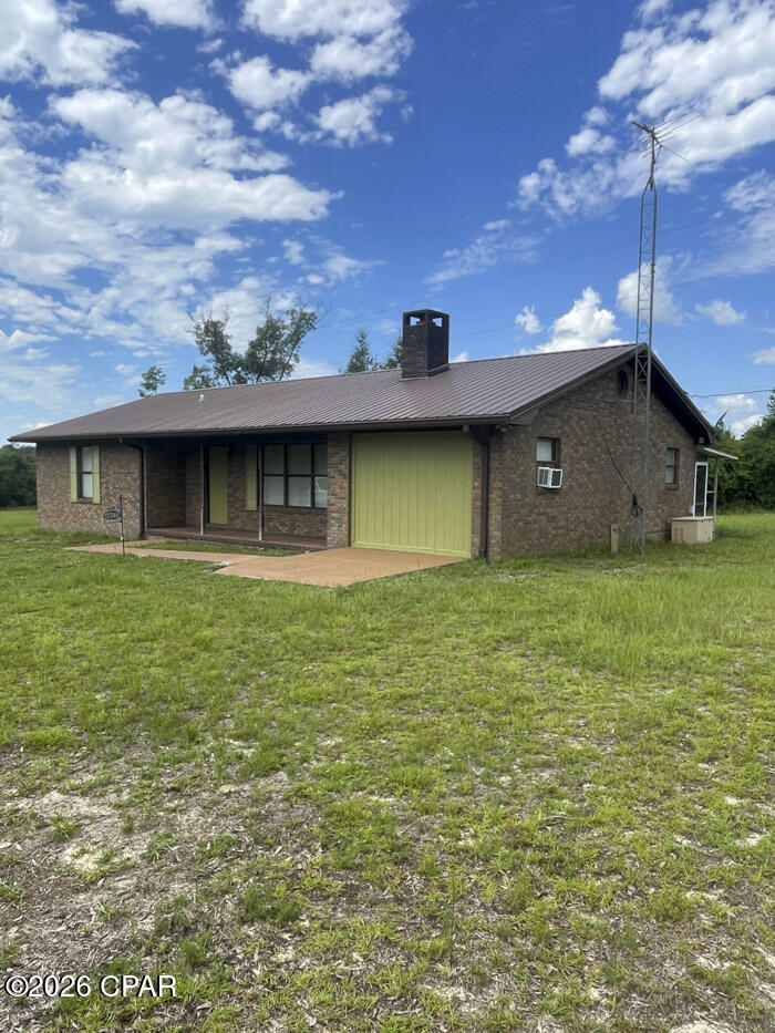 $289,000. Country living at it's best! This home is off the beaten path down a private lane. Inside was recently painted, bathrooms were upgraded, new vinyl plank flooring in all rooms except bathrooms, which are tiled, and a new refrigerator was put in the kitchen. There is a gas-powered generator which provides ample electricity during power outages. The 13' x 21' living room has a nice brick fireplace; the original carport is 12' x 20' and is completely enclosed for added living space and has a window unit for heating/cooling. Master BR is 12' x 13.5', and has a 5' x 6.5' walk-in closet. The 2nd BR is 12' x 12' and both BR closets have very nice custom built shelves and drawers. Right out of the 12' x 22' kitchen/dining combo is the 9' x 10.5' laundry that comes equipped with washer, dryer, and laundry tub. Step out of the laundry onto the covered 9' x 25' back porch that is partially screened. The 6.43 acres offers plenty of room for gardening or other expansion. For the handyman or hobby enthusiast, there is a 15' x 30' concrete block shop with power, water, and also a 2nd refrigerator. In addition to the concrete block shop building, there is an industrial type metal warehouse or workshop building that is about 30' x 50' overall, plus a 20' x 30' covered front shelter and open 10' x 30' and 15' x 30' lean-to on each side. This warehouse building has concrete flooring, some insulation, power, water, and a bathroom. Travel to Panama City Beaches within 45 minutes from this property. Tyndall Air Force Base or Mexico Beach are also just a short drive away. This property has so much to offer for the reasonable price of $289,000!