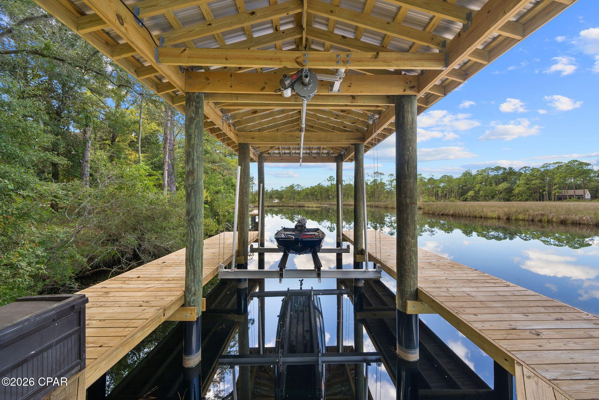 Situated on nearly three-quarters of an acre, this exceptional waterfront property offers privacy, space, and coastal charm. The home features 4 bedrooms, 3.5 bathrooms, and a 3-car garage, with a flexible layout designed for comfortable living and entertaining. A private bedroom, bathroom, and living area provide the perfect setup for a mother-in-law suite, guest quarters, or home office. Two additional guest bedrooms share a spacious bath with double vanities, while the open living areas create a warm and inviting atmosphere. The kitchen overlooks the main living space and includes quartz countertops, a farmhouse sink, stainless steel appliances, and a large island with bar seating. Adjacent dining and breakfast areas offer plenty of room for everyday meals and gatherings. Enjoy direct access to Choctawhatchee Bay from your private covered boat slip with boat lift! This makes boating, fishing, paddleboarding, and sunset cruises easily accessible directly from your backyard. Surrounded by mature landscaping in a peaceful South Walton County setting, this property presents a rare opportunity to enjoy waterfront living with room to grow. Whether you're looking for a primary residence, second home, or investment property, this home is ready for your personal touch. Conveniently located just minutes from the Emerald Coast's renowned beaches, dining, shopping, and entertainment, this is waterfront living at its best.