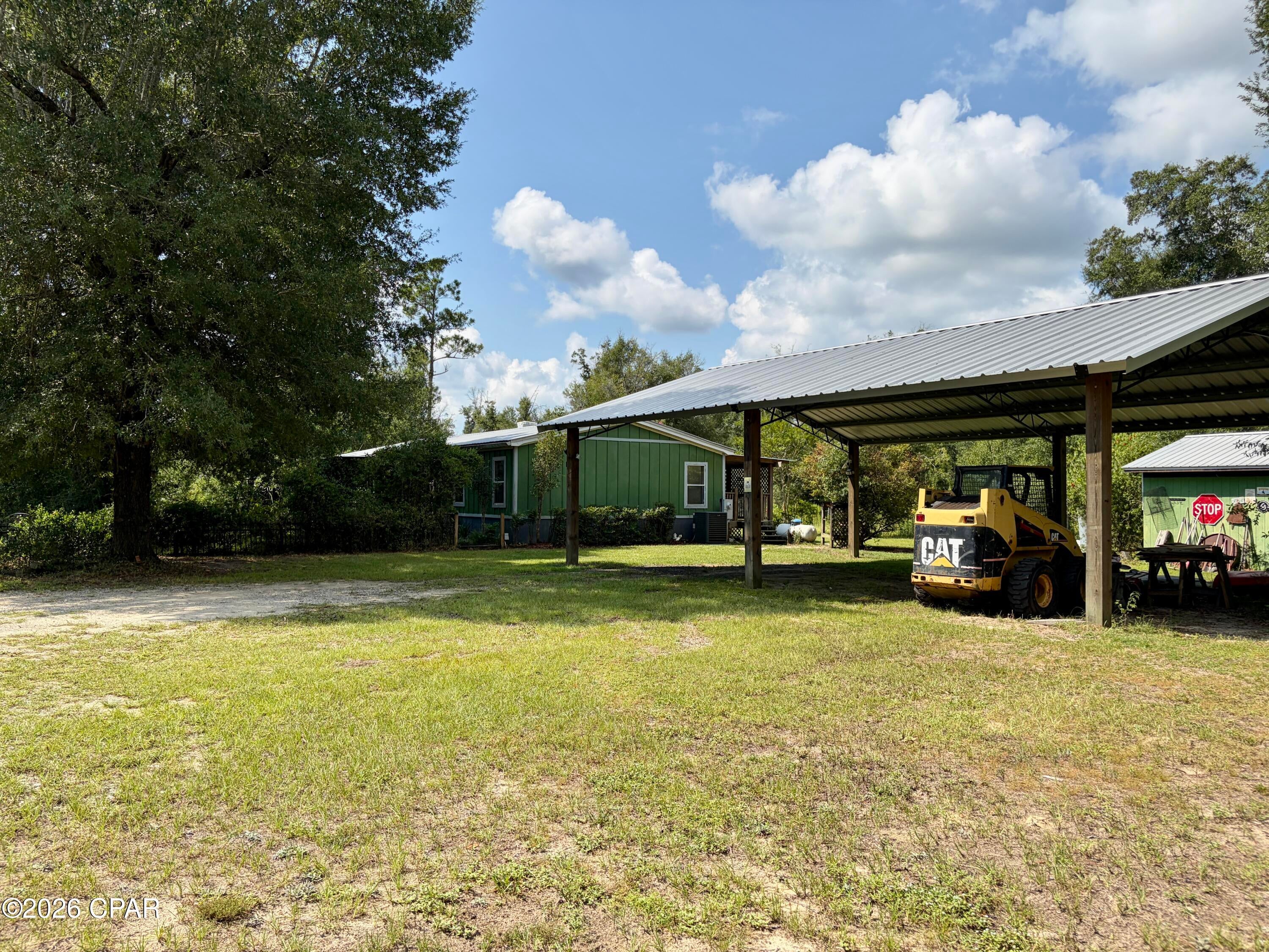 Enjoy peaceful country living on this private, fully fenced .835-acre property, offering plenty of room for work, storage, and outdoor living. The home features a durable metal roof installed in 2013, Hardie board siding added after Hurricane Michael, and a 2024 HVAC system with a five-year warranty. Inside, the kitchen is full of character with beautiful cypress countertops and a gas stove, while every bedroom includes a spacious walk-in closet.

A new well was installed in 2025, and an additional shallow well is also located on the property. Outside, you'll find a large pole barn with 12-foot eaves built in 2024, a versatile container, and a workshop/storage shed with a concrete floor. The grounds are filled with an impressive variety of well-established plants, including Mardi Gras honeysuckle, clumping bamboo, loquat, root beer plant, Disney ginger, turmeric, rosemary, swamp sunflowers, azaleas, bottlebrush, pindo palms, lemongrass, blooming aloes, Mexican petunias, and pineapple guava. This unique rural property offers privacy, functionality, natural beauty, and plenty of possibilities.
Please note the fireplace is capped.