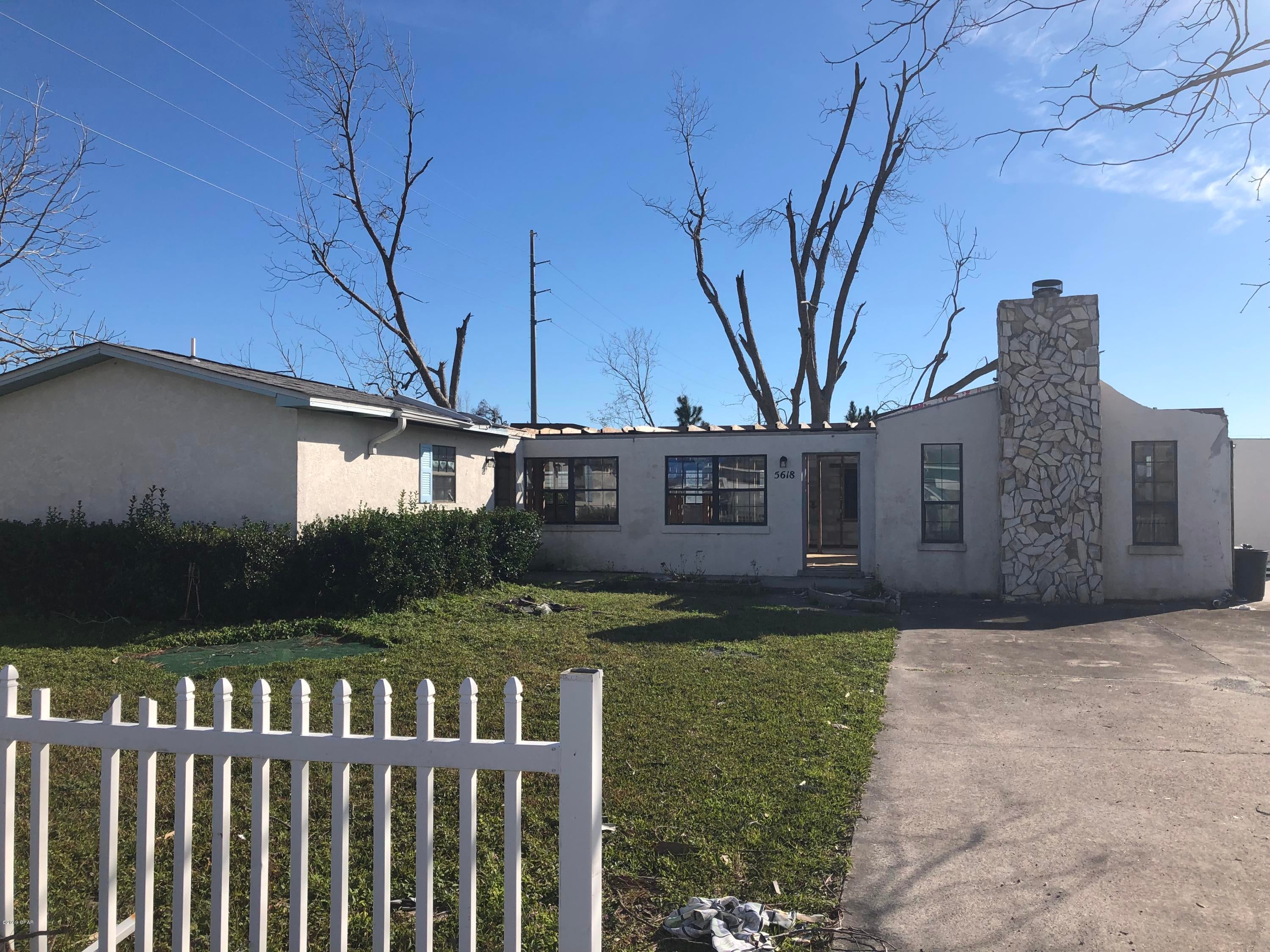GET CREATIVE- The lot is amazing in that it is a 3/4 acre CORNER lot. It is in the first block of Lilly Street, just off Tyndall Parkway near PepBoys.  After Hurricane Michael blew through, it left this home with a very nice fireplace that is still standing ---but no roof and not much else in the interior.  Hold onto the lot for future use, demolish the house and rebuild, or re-hab the home.  Commercial property is right next door so this parcel could possibly be used in a different way by checking with the zoning and building departments.  You truly have an open slate but some barely visible utility wires overhead on one part of the lot could limit what you do in that area of the property.