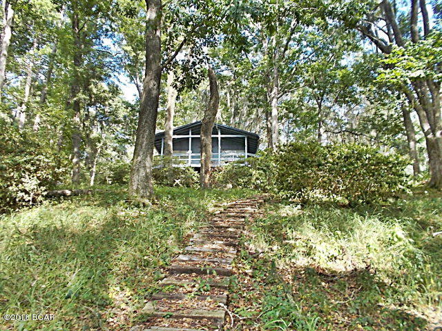 WATERFRONT !!! SELLER HAS AGREED TO DO OWNER FINANCING, CALL AGENT FOR DETAILS. Own your private get-a-way spot on beautiful Ocheesee pond,a 2200 acre lake that is full of bass, brim,and crappie. This cottage is just perfect for a retirement home or a place to vacation boating and fishing. It has a covered boat dock to keep the boat dry. The wood walkway leads up to the cottage.All on a dirt road for peace and quiet, but just a few blocks off a paved road. This little area is well know for a fishing community. Bring your boat and enjoy the quiet life. New power line and breaker box installed in April 2014