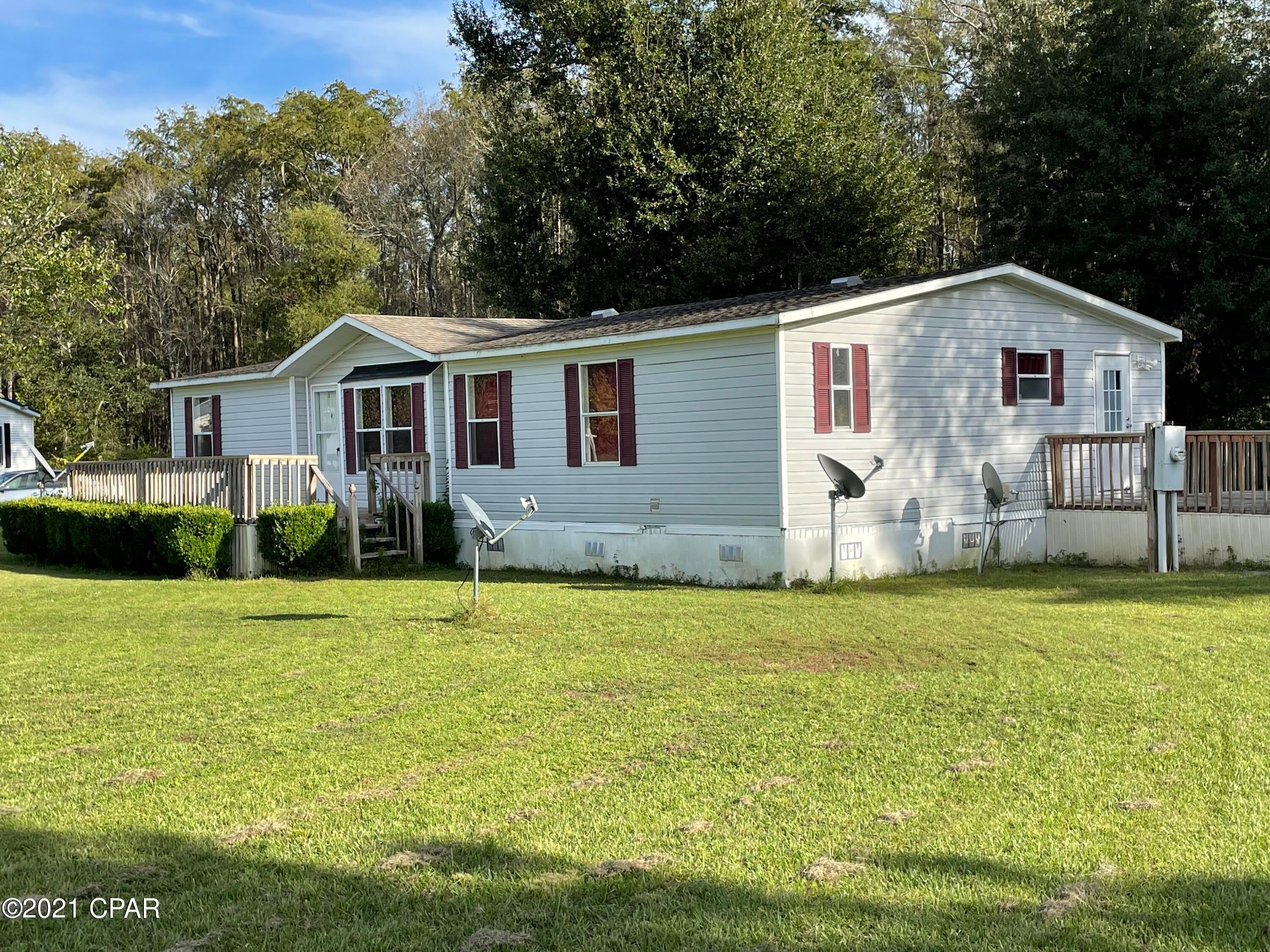 $99,000. 'CURRENTLY UNDER CONTRACT, SELLER ACCEPTING BACKUP OFFERS' This comfortable 3BR/2 bath double-wide mobile home is situated on 2.25 acres in a quiet subdivision just off US 90 in a small, rural area of NW Florida. Drive about 1 hour to Dothan, AL, or just over an hour to Panama City and the beaches. The 1998 home has 1,456 s.f. of heated/cooled living space, with heating and cooling system that was replaced in 2017. Recent new carpet, new stove, new refrigerator, and new washer/dryer. There is city water and sewer at this location. Owner will consider selling some of the furnishings if buyer is interested. Home is located just a short drive to Walmart, restaurants, doctors, and hospital. Make your plans to visit this turn-key home today! $99,000