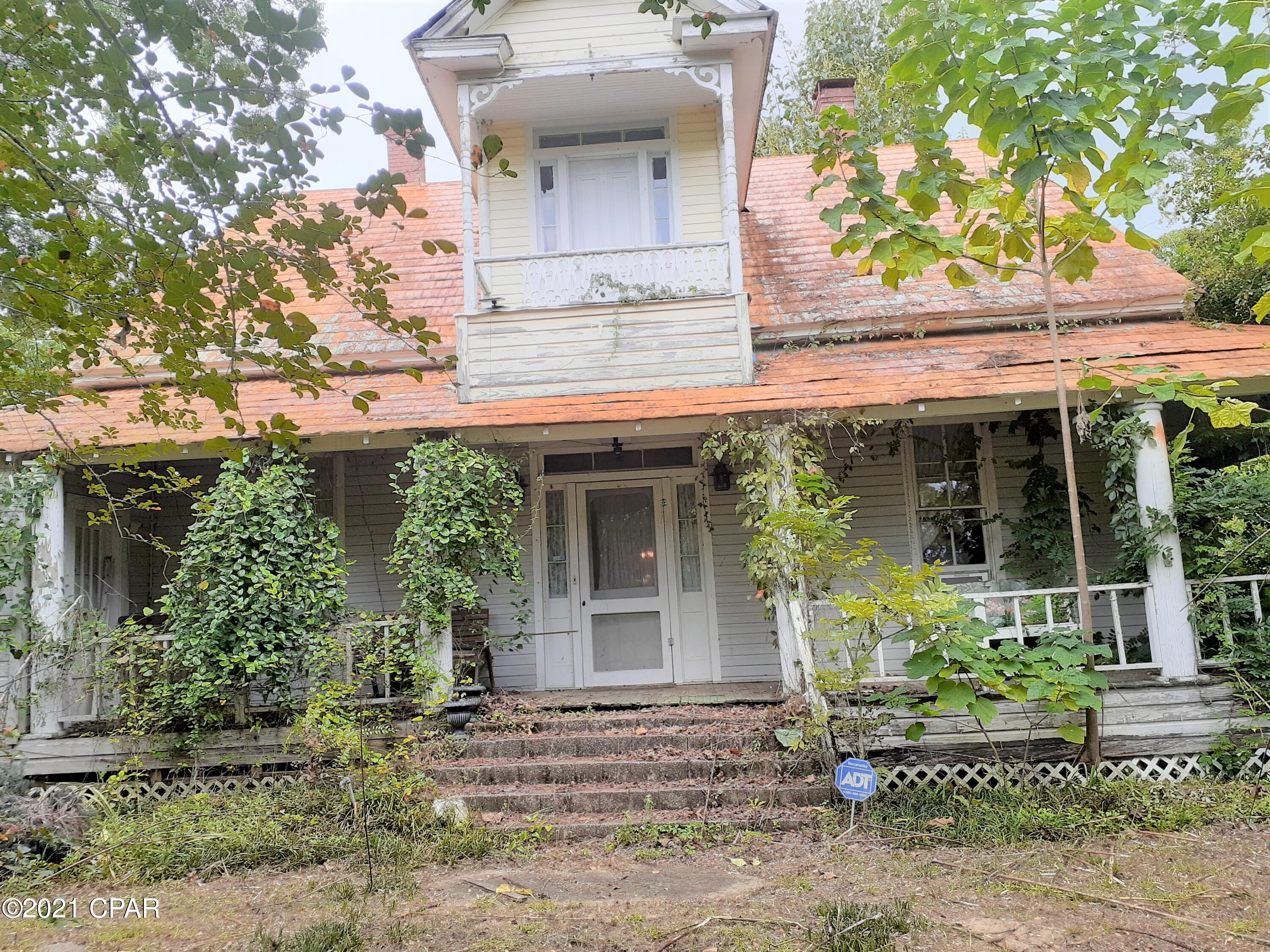 Diamond in the rough. Turn of the 20th century, 2-story home has 3 porches for  you to enjoy the summer breezes. Two upstairs bedrooms have no bath.  One bath downstairs.  Home has had few updates since it was built.  Kitchen remodeled a few years ago. House has a  lot of stuff &  furniture inside.  Needs cleaning & clearing out debris.  Grounds are overgrown.

Mobile home power pole  in back.  Needs new well.  Would make a nice country home, when restored. The  3.2 acres behind house has power pole for M.H. and room  for a garden.  Lemon tree. Balconey off upstairs bedrooms. 5 fireplaces.  High ceilings. Rented Gas tank.  SELLING ''AS IS '' WHERE IS'' Title is transfered by quit-claim deed-no title ins.  DO NOT WALK ON PORCH ON N SIDE OF HOUSE. ROTTEN FLOOR BOARDS.

SEE AGENT TO AGENT REM