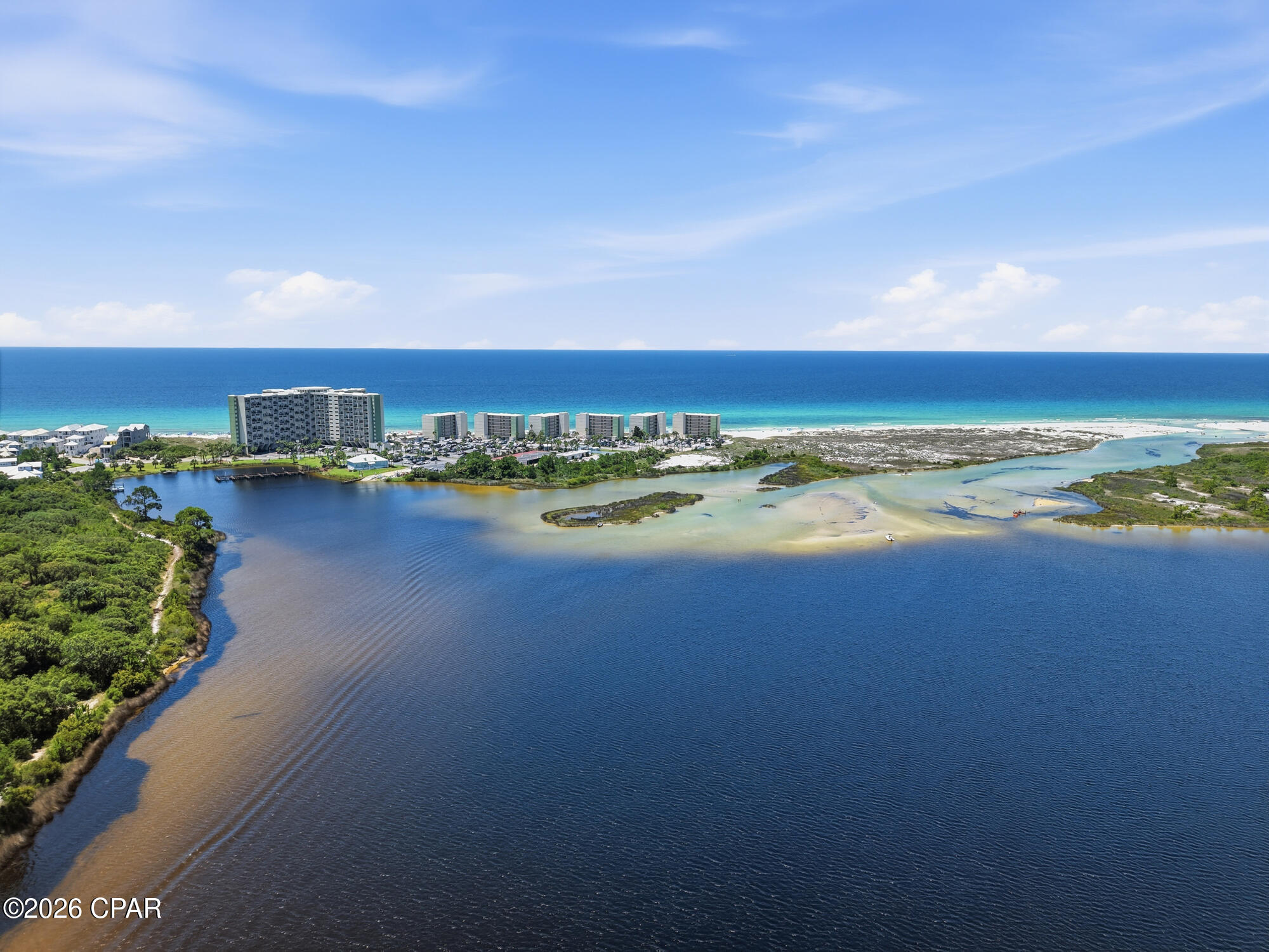 One of the few opportunities currently available at Pinnacle Port with an EXCEPTIONAL rental history, this beautifully maintained condo offers an impressive calendar of bookings (almost everyday turn around!), outstanding 5-star guest reviews, and a loyal base of returning visitors year after year. Those are most valuable trades in vacation rental business that is already established for this property!. Professionally staged( yes, owner paid for it!), fully furnished, and truly turnkey, it's ready to continue its success as a high-performing vacation rental or become your own private coastal retreat.

Finally, a waterfront property where you don't have to choose between the Gulf and the lake. Here, you can enjoy breathtaking Gulf sunsets from your living room while overlooking the peaceful waters of Lake Powell from the dining area and primary suite - a combination so rare that it truly sets this condo apart. 

Inside, the thoughtfully updated interior features an open-concept kitchen with granite countertops, a breakfast bar, and spacious living areas designed for entertaining. Upstairs, the loft has been transformed into a private retreat with a custom stone and tile shower and a sliding barn door, creating a flexible space for owners and guests. Unit perfectly located in the center of the building at perfect height, and close to the elevator!

Pinnacle Port is one of Panama City Beach's most unique waterfront communities, tucked behind the gates of Carillon Beach on 25 acres where the Gulf of America meets Lake Powell - Florida's largest coastal dune lake and one of the world's rare ecosystems where freshwater naturally connects with the Gulf. Spend your mornings watching dolphins offshore, your afternoons boating or fishing on the lake, and your evenings enjoying spectacular sunsets--all without leaving the community.

Residents enjoy two pools, tennis and pickleball courts, a fitness center, sauna, private marina with boat slips and boat launch, fishing dock, and direct beach access. Bordering Camp Helen State Park, you'll also enjoy miles of preserved coastline, hiking trails, kayaking, wildlife, and one of the most peaceful stretches of beach along the Emerald Coast.

Just minutes from the boutiques, restaurants, and entertainment of 30A, Rosemary Beach, Alys Beach, and Pier Park, Pinnacle Port feels like a secluded island retreat while remaining close to everything the Emerald Coast has to offer.

An added bonus? Association dues include electricity for heating, cooling, and hot water, helping keep ownership costs more affordable.