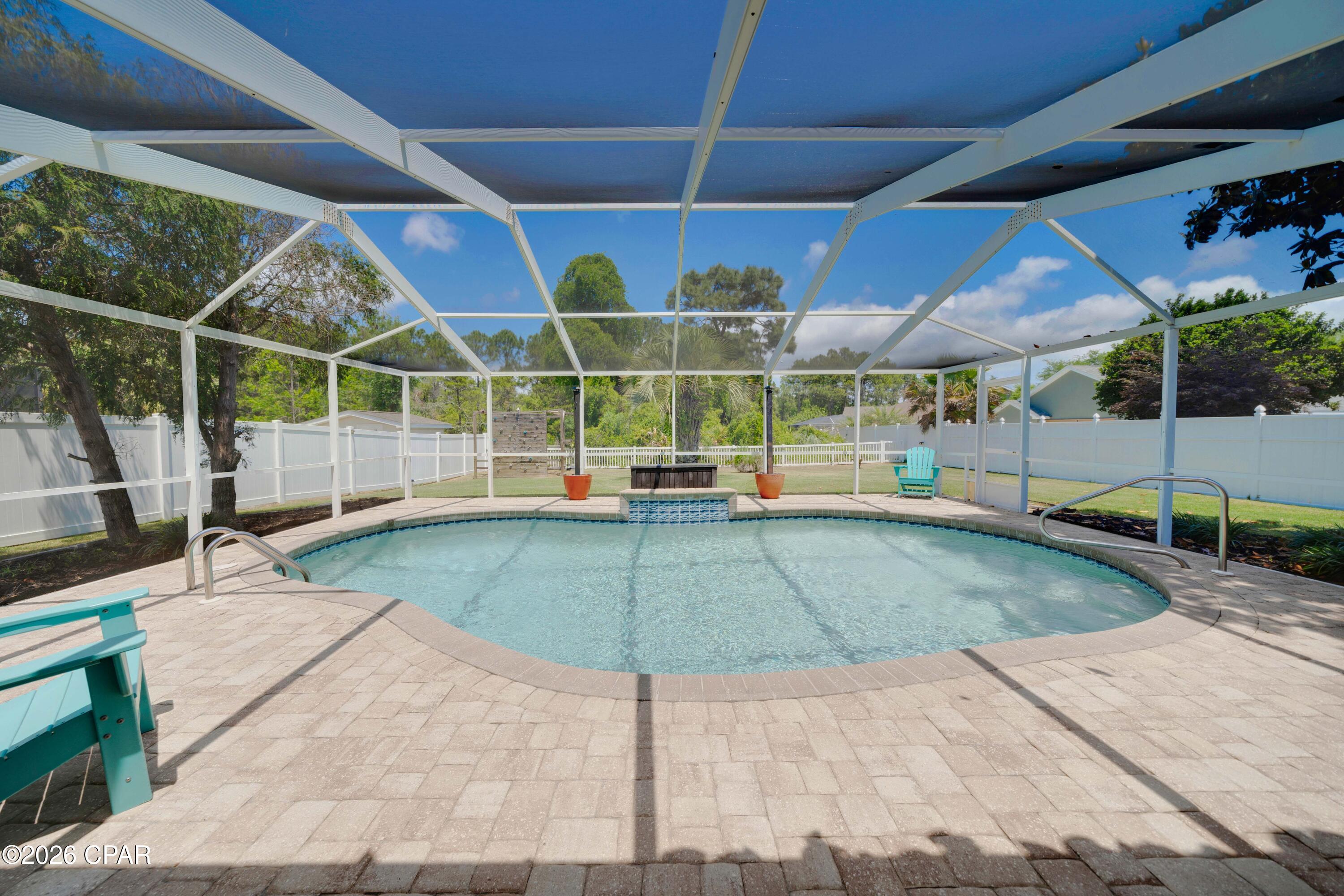 Lowest priced home with a pool in Palmetto Trace.  This beautifully updated 4-bedroom, 2.5 bath home with a private screened-in pool is move in ready!  This is one of the most desirable homesites in the community. Backing to a serene nature preserve, this property offers exceptional privacy with no rear neighbors. This move-in-ready home showcases fresh interior and exterior paint, a roof less than 4 years old, luxury plank flooring, newer HVAC, and new pool equipment. The updated kitchen features brand-new cabinetry, while the renovated primary bath offers a stunning walk-in shower. A split-bedroom floor plan provides added privacy, and two separate living areas create flexible space for both relaxing and entertaining. Additional highlights include plantation shutters, a covered porch, and a spacious backyard. Residents of Palmetto Trace enjoy access to two community pools and a prime location just minutes from the  beaches of Panama City Beach, an easy golf cart ride away. You're also close to Pier Park, Topgolf Panama City Beach, and Frank Brown Park, along with top shopping, dining, and entertainment options. A fantastic opportunity to own an updated home with highly desirable location in one of Panama City Beach's most sought-after communities. Truly move-in ready, call us for your showing today!