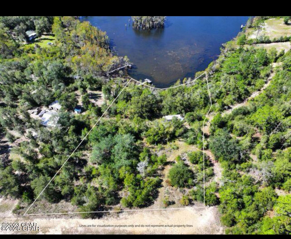 LAKEFRONT HOMESITE ON BEAR POND - JUST OVER 1 ACRE
Enjoy peaceful, secluded living on just over one acre overlooking the quiet waters of Bear Pond. This natural homesite offers a rare blend of privacy and convenience, tucked away from the hustle of the city yet still an easy drive to Panama City Beach for shopping, dining, and entertainment.

A dilapidated mobile home currently sits on the property and is being sold at no value. Seller has no knowledge of an existing septic or well, giving you the freedom to evaluate and plan improvements according to your needs. The property includes a small dock, perfect for relaxing by the water or launching a kayak. (Bear Pond does not allow motorized boats, preserving its quiet, serene atmosphere.)

With no restrictions and no build-time requirements, you can create your ideal retreat on your own schedule. Outdoor enthusiasts will appreciate being just a hop and a skip from Econfina Creek, known for its crystal-clear waters and endless opportunities for swimming, paddling, and exploring.

This is a wonderful opportunity to own a private lakefront parcel in the Florida Panhandle--whether you're ready to build now or invest for the future.
