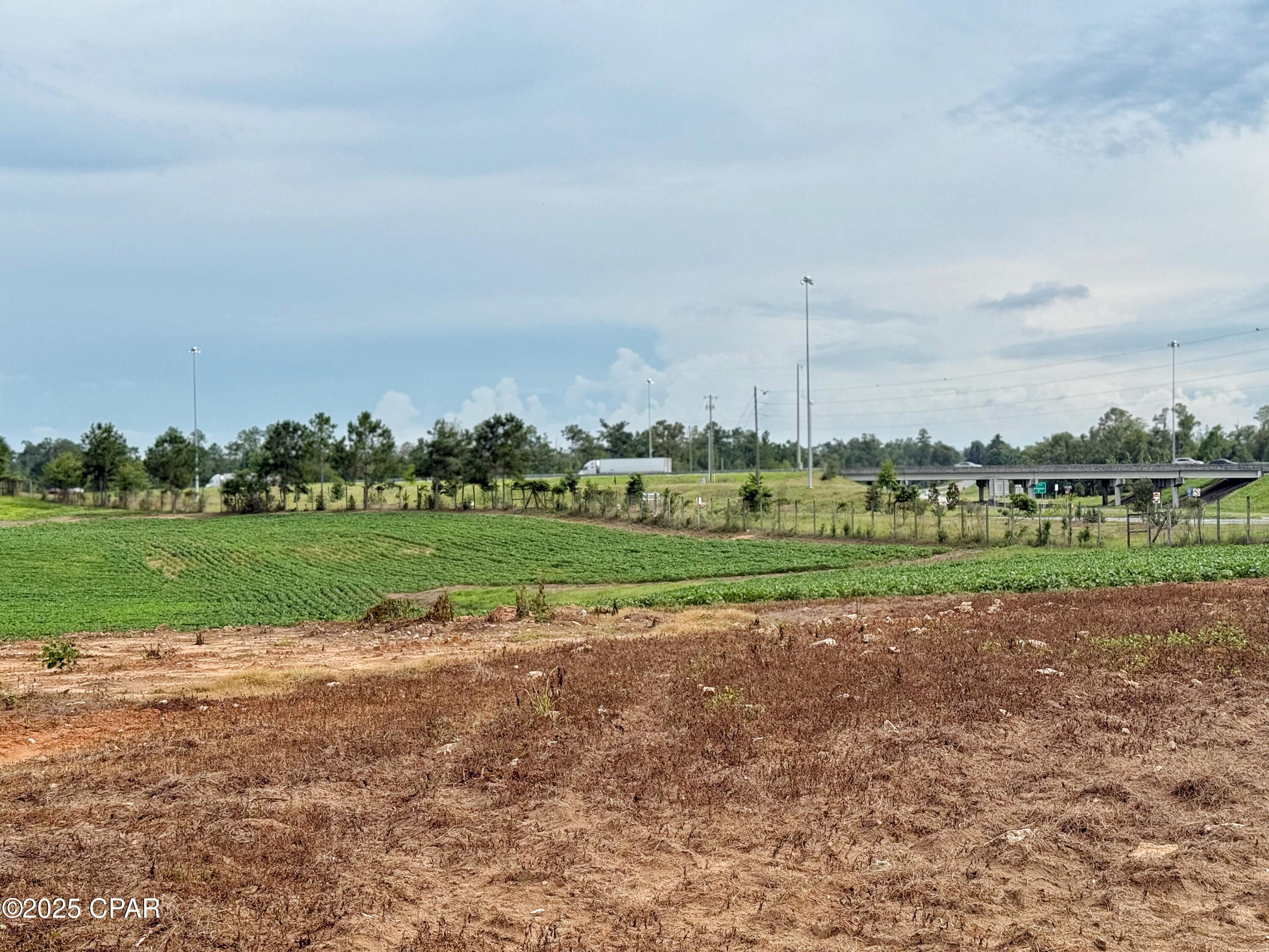 Prime property located on I-10 Exit 152 and Hwy 69 in Northwest Florida between Tallahassee and Pensacola, Fl.  This 18.06 acre tract has visibility from Interstate 10 being located immediately on the North East side of the Interstate.  It is currently in row crop with tons of potential for future.  Public water and sewer currently being installed directly N of this parcel .  There is a well and power pole existing on the property. Some of the property is located in the City of Grand Ridge and some located in the County of Jackson. Endless development possibilities! Currently zoned residential and light industrial. Can be divided.  Seller will entertain selling all or part of the property.