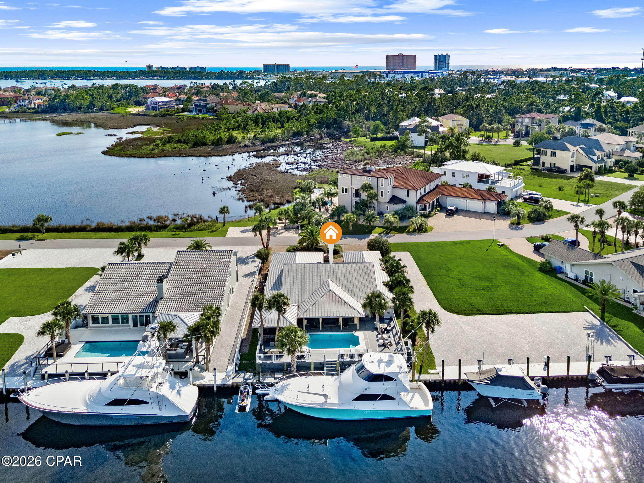 Welcome to 553 Wahoo Road, a beautifully appointed waterfront home in the gated Bay Point community. Ideally positioned east of the Bonefish Bridge, the property offers 80 feet of water frontage with no overhead obstructions, making it ideal for large boats with towers. Located near the beginning of the canal system, the home is less than a ten minute ride through the no wake zone to open water. Additional boating features include a vinyl seawall and 50 amp shore power.

This spacious four bedroom, four bathroom home is filled with natural light and showcases vaulted ceilings, skylights, a living room fireplace, and water views from both the front and rear. The well equipped kitchen features a Viking gas cooktop, Viking oven, and Viking microwave, while the wet bar with beverage cooler makes entertaining effortless.

Outdoor living is equally impressive. Relax beside the heated swimming pool, take in the waterfront views from the oversized elevated rear deck, or entertain guests in the covered outdoor kitchen, complete with a Big Green Egg, gas grill, and single gas burner. It is the perfect setting for cookouts after a long day on the water, with generous areas for lounging and gathering.

Additional features include a standing seam metal roof, paver driveway, whole house rain gutters, single car garage, and Generac generator.

Nestled securely within Bay Point, residents enjoy amenities that include manned entrance gates with guards and roving security. Bay Point is home to the Nicklaus Golf Course, the only one in Northwest Florida, as well as Point South Marina, a full service facility with a fuel dock and slips accommodating yachts up to 120 feet. This exceptional property brings together convenient boating access, comfortable coastal living, and outstanding spaces for entertaining.