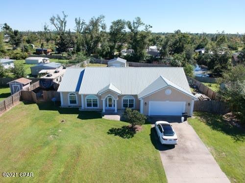 This lovely home offers water access to Bayou George and Deerpoint Lake.  The home has a welcoming foyer which leads to to a formal dining and and entry sitting room, office or the 4th bedroom.  You then enter into a very open concept living room with fireplace and a kitchen with breakfast nook.  The kitchen has white cabinetry, slate gray countertops stainless appliances and tiled flooring.  There is a breakfast bar with additional seating for 4.  The bedrooms are split with two on one side of the living area along with a full bath and on the opposite side, the large master suite with a very large walk in closet, ensuite with whirlpool tub, double vanities, toilet room and a lovely walk in tiled shower.  This side of the home also has the laundry room and entry to the oversized garage. On the back of the home there is a Florida Room that was added in 2010 that has a wall unit for air and heat.  It is the perfect size for entertaining and currently home to a bar, pool table and a poker table...a mans dream "man cave".  As you enter the back yard from the door to your right you will find a very large concrete patio.  The .68 acre lot also offers, water frontage to a canal that will take you to Bayou George or Deerpoint Lake.  Additionally, there is a 20X24 metal shed and a 40' parking pad for an RV with a 30 amp receptacle next to the RV pad.  There is also a small dog area for your fur babies and for the gardener, several varieties of fruit trees and a ready made tomato garden near the shed as well.  Last, but certainly not least, a oversized two car garage with walk around attic space offers a ton of additional storage.   This home offers so much, just outside of town but very close to everything.  Don't miss seeing this wonderful home, call your favorite Realtor today!
