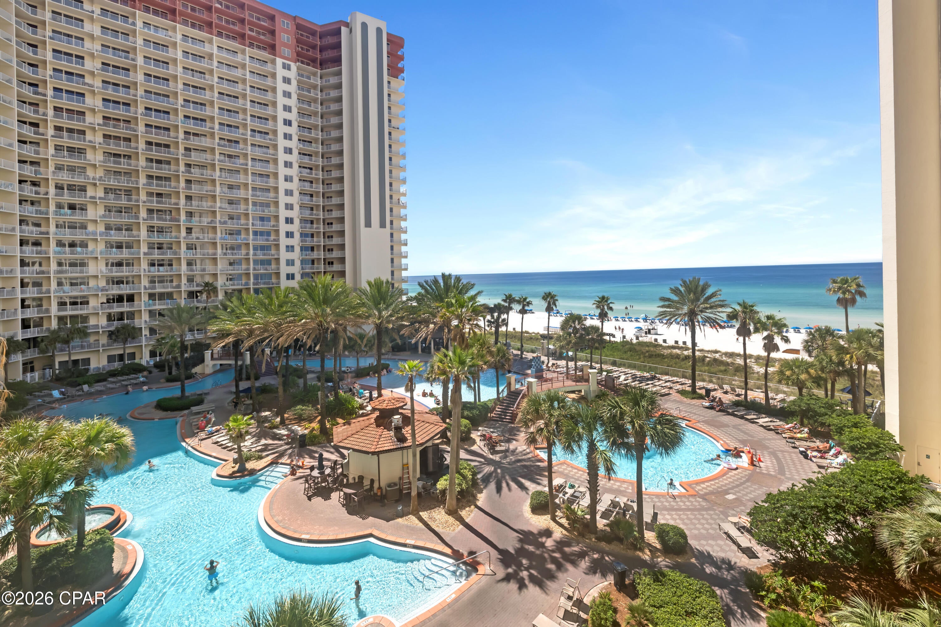 LOW FLOOR. LEASED PARKING SPACE. FRONT DOOR BY THE ELEVATOR. Shores of Panama 510 is a furnished, fifth-floor Type F floor plan in Panama City Beach featuring one bedroom, a bunk area, one full bathroom, and one half bathroom. The balcony offers views over the resort pool and out to the Gulf.
The recently painted interior is decorated in a light coastal style and features tile flooring throughout. The kitchen includes granite countertops, stainless steel appliances, and a stackable washer and dryer. Near the entry, the bunk area provides additional sleeping accommodations, with the half bathroom conveniently located nearby. The primary bedroom includes a king-size bed and access to the full bathroom.
The unit also has a leased parking space on the 6th floor (658), and the front door is positioned immediately near the elevator. Additional updates include a 2020 HVAC system and a 2019 water heater.
Shores of Panama is a Gulf-front resort centered around an expansive zero-entry lagoon-style pool with palm-lined islands, fountains, and a large outdoor hot tub. Additional amenities include private beach access, an indoor heated pool and hot tub, a 24-hour fitness center, a seasonal poolside Tiki bar, and covered parking.
Located in the heart of Panama City Beach, Shores of Panama is adjacent to Pineapple Willy's and directly across from Laketown Wharf, offering nearby dining, shopping, and entertainment. Additional Panama City Beach attractions include Pirates Voyage Dinner & Show, Topgolf, McGuire's Irish Pub, and Tootsie's Orchid Lounge.
HOA dues are currently $3,507.11 per quarter. One special assessment installment remains in the amount of $1,218.04, due in the fourth quarter of 2026. All information is deemed reliable but not guaranteed; buyer to verify if important.