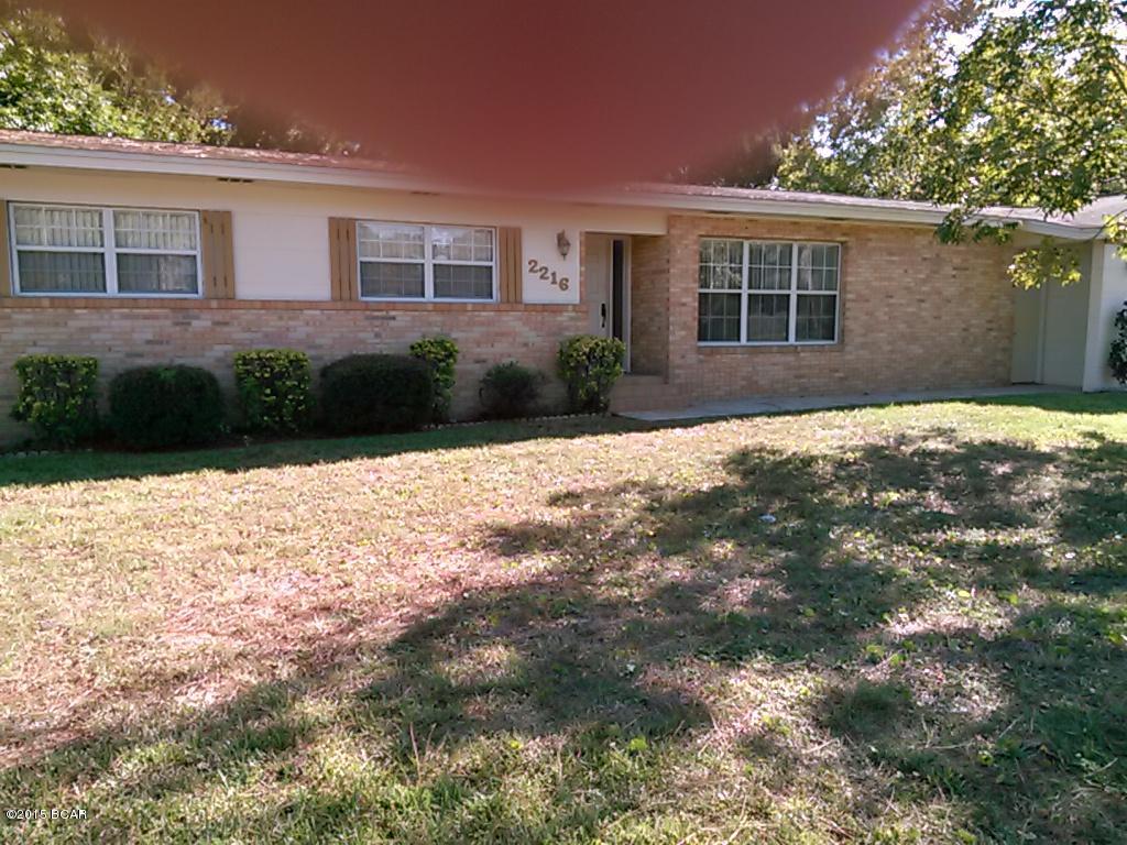 Great buy! Well kept block & brick home in Hiland Park-Lynn Haven area. Half acre corner lot with chain link fenced back yard.  Home has pretty hardwood floors in every room (some under carpet), spacious living room with fireplace, roomy kitchen with 2 desk areas plus eat-in area, formal dining room with oak hardwood floors, ample size bedrooms, baths have been updated with tile shower, tub & vanity.  All electric home with central HVAC (under warranty w Peaden AC). 2-Car Carport under roof of home faces side street.  Lots of storage space with 2 built-in rooms off carport. Metal storage building in yard with added slab and roof for extra boat parking.  Landscaped yard has pecan trees (loaded with pecans) and many mature azaleas, plants & flowers. Inside laundry room. Screened porch.