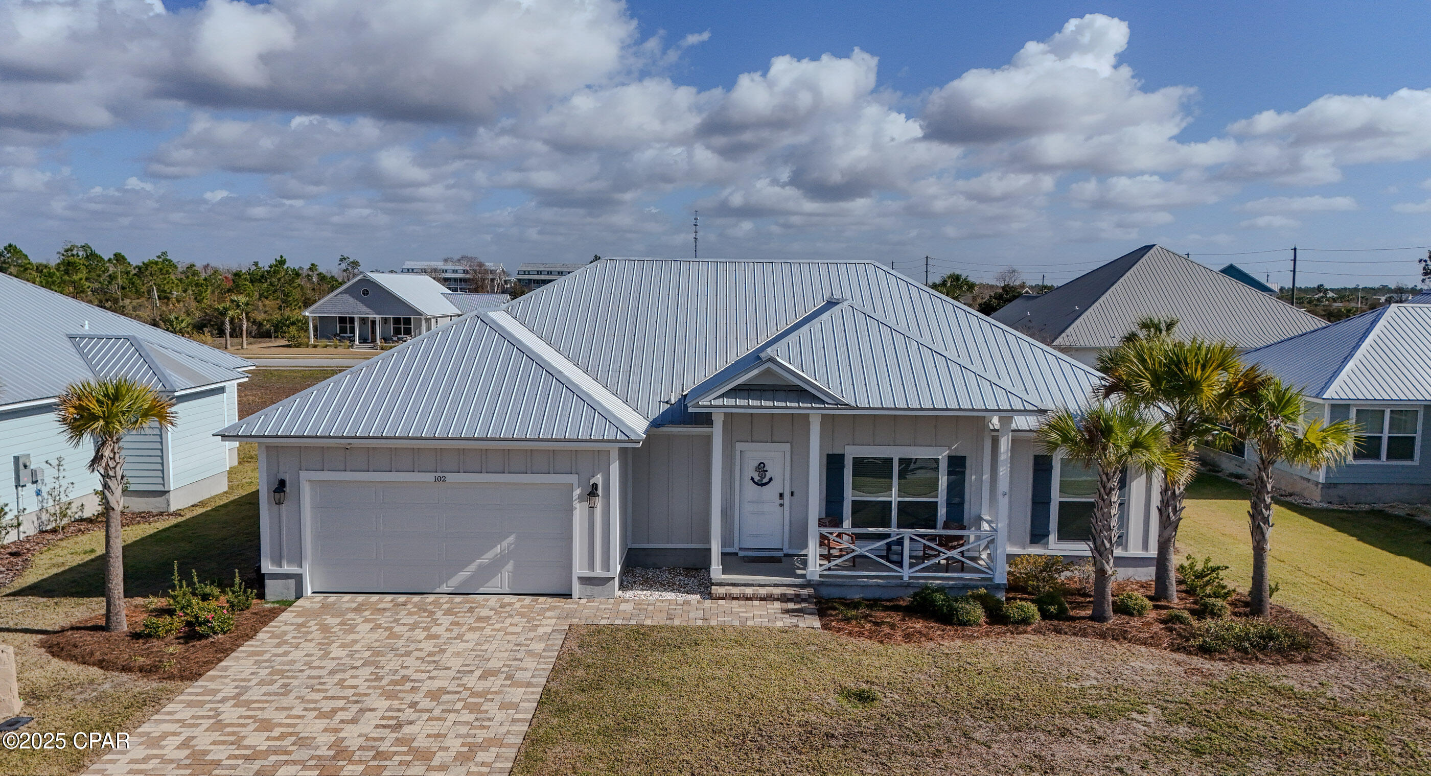Welcome to 102 St. Charles Lane, a thoughtfully designed and impeccably cared-for home located in the desirable Casuna neighborhood of Mexico Beach. Built in 2021 and situated in the sought-after X flood zone, this 3-bedroom, 2-bath residence offers the perfect balance of modern construction, coastal charm, and low-maintenance living. From the moment you arrive, the enlarged front porch, metal roof, and durable Hardie-board siding set the tone for quality and curb appeal. Inside, the home feels fresh and inviting with luxury vinyl plank flooring, granite countertops, and a well-appointed kitchen featuring stainless steel appliances, including a gas range—ideal for both everyday living and entertaining. The layout is functional yet comfortable, designed to live well year-round. A tankless gas water heater provides endless hot water, while the spacious two-car garage with epoxy flooring adds both style and practicality. Outside, the fully landscaped yard, paver driveway, and full sprinkler system make upkeep easy, allowing you more time to enjoy the coastal lifestyle. Residents of Casuna appreciate the peaceful neighborhood atmosphere, friendly community feel, and access to amenities such as a community pool and clubhouse. Best of all, you're just a short golf cart ride from the beach, local shops, and restaurants. This move-in-ready home is ideal for full-time living and offers a quiet, well-kept setting with pride of ownership throughout. With no short-term rentals allowed, Casuna maintains a true neighborhood feel—making this home an excellent opportunity to enjoy coastal living with comfort, quality, and community at the forefront.