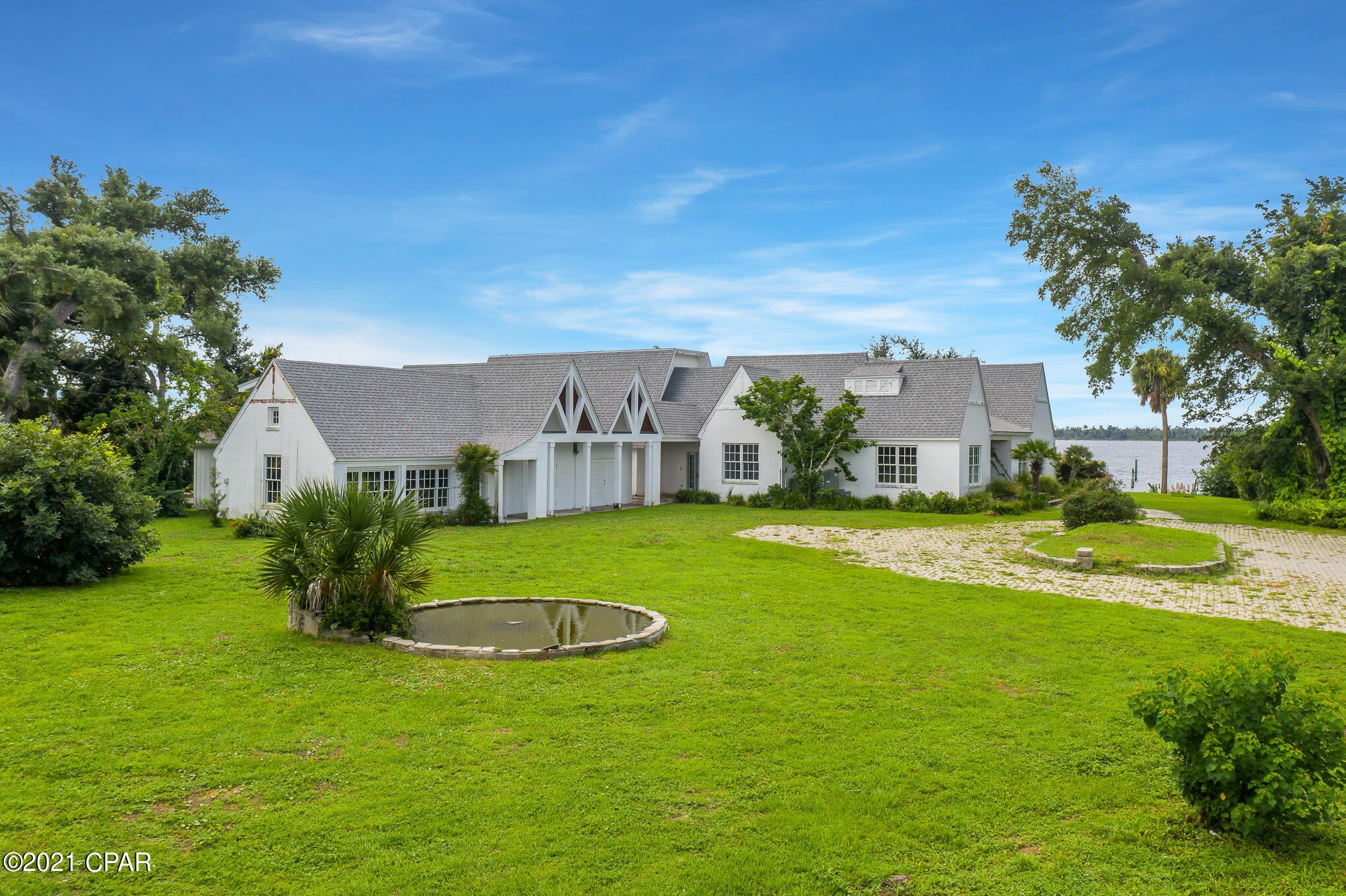 Reigning as one of the most sought-after locations in the panhandle, this iconic Bunkers Cove waterfront estate affords breathtaking views of St. Andrews Bay and is embodied with rich history of the Sudduth family and the vision of developer, H.L. Sudduth, that is still being carried out to this day. Built by the Sudduth Family as their primary residence in 1932, this prominent and historic home sits on 1.36 ACRES and 3 homesites. The value of this land is incredible! Leader of the family, H.L. Sudduth, is credited for the development of the Cove neighborhood from inception over 100 years ago and chose this specific homesite for his own private residence. An incredibly rare opportunity is available to revive, restore and preserve a piece of Cove history with this beautiful, architecturally striking Bayfront manor.

Views of the shimmering water immediately attract attention as you travel through the foyer and into the main living area. Beamed ceilings and custom windows surround while thoughtfully-designed arched openings provide the perfect flow to the stunning dining room with exquisite natural lighting and French doors to the patio. A Chef's kitchen is ideal for family baking on the sprawling island and considerate in design for overflow onto the patio, connecting the outdoors to both the main home and the bonus room ensuite. Integrated with flagstone patio and walkways, this area is excellent to create your own high-end Summer kitchen and outdoor seating area. Positioned with entertaining of utmost importance, the pool and spa are designed for maximum enjoyment of the entire property. With 90' Bay frontage and 180 degree views, this home gives you the desirable deep water access for your Sportfish or center console boat. A short boat ride to Shell Island and only minutes from the open Gulf of Mexico, this is a Fishermans dream. 

The main home offers 5 bedrooms with 5 bathrooms is complete with a bonus room ensuite off of the vaulted mudroom breezeway to the 2-car garage. A carriage guest house overlooking the famed Bunkers Cove Road offers space for a charming guest suite with a sizable living area and full kitchen connectivity. Great for rental potential or to hosts your guests. Deep water with pure views of the bay and a 6-8' draft year-round ideal for those who desire to live on the open Bay.

This one-of-a-kind Bunkers Cove home is ready for a detailed and authentic restoration, one that will preserve its history and elegance as has been told for many generations before us. This home still has a story to tell. Inquire today and start living the coastal lifestyle you deserve.

The home has been through remediation after Hurricane Michael and is being sold AS-IS. To help visualize the potential of this incredible waterfront renovation, virtual renderings are shown. All information provided is deemed reliable, but is not guaranteed and should be independently verified.