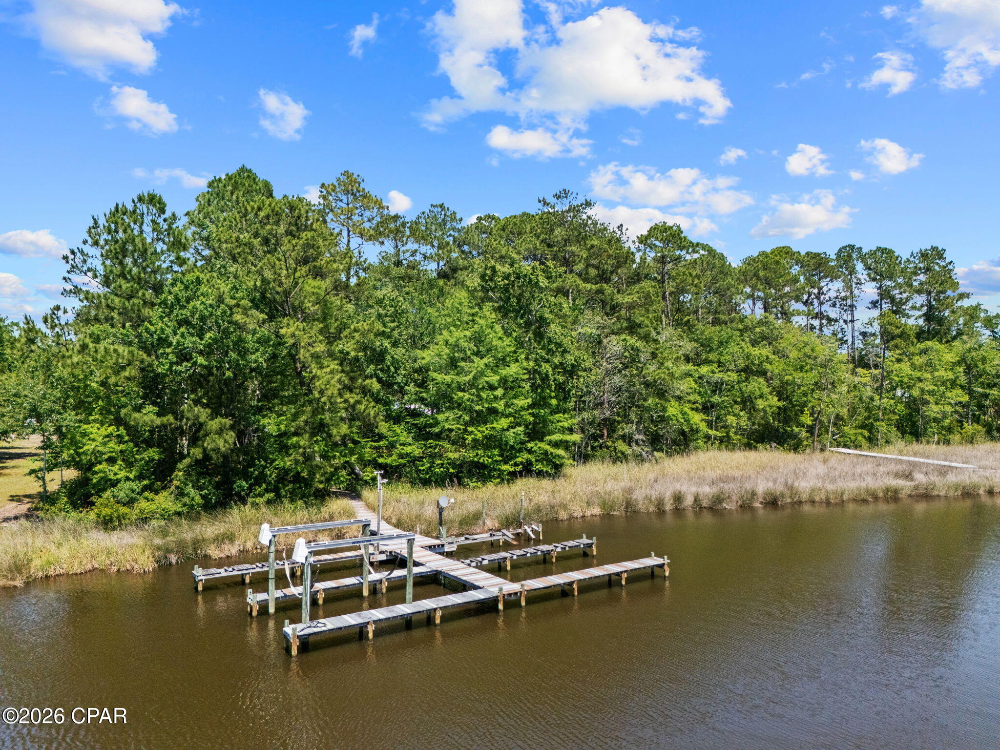 MOTIVATED SELLER - BRING ALL OFFERS! Enjoy waterfront living on beautiful Mallet Bayou with approximately 100 feet of water frontage and direct access to boating, fishing, kayaking, Choctawhatchee Bay, and the Intracoastal Waterway. This unique property features a private dock with four slips and a boat lift rated for up to 3,000 lbs.

The home offers a spacious screened porch overlooking the water, a wood-burning fireplace, double-pane windows, foam attic insulation, durable Hardie board siding, and a new metal roof installed in 2024. In addition to the attached two-car garage, the property includes a detached garage/workshop, RV pole barn, carport, greenhouse, and mower shed, providing ample storage and workspace.

With no HOA and unrestricted use, this property offers incredible flexibility for boaters, hobbyists, RV owners, and those seeking room to spread out. Conveniently located near Freeport's shopping, dining, marinas, schools, and just a short drive to the beaches of South Walton.

Motivated seller says bring all offers! This is a rare opportunity to own a well-equipped waterfront property with endless possibilities on Mallet Bayou.