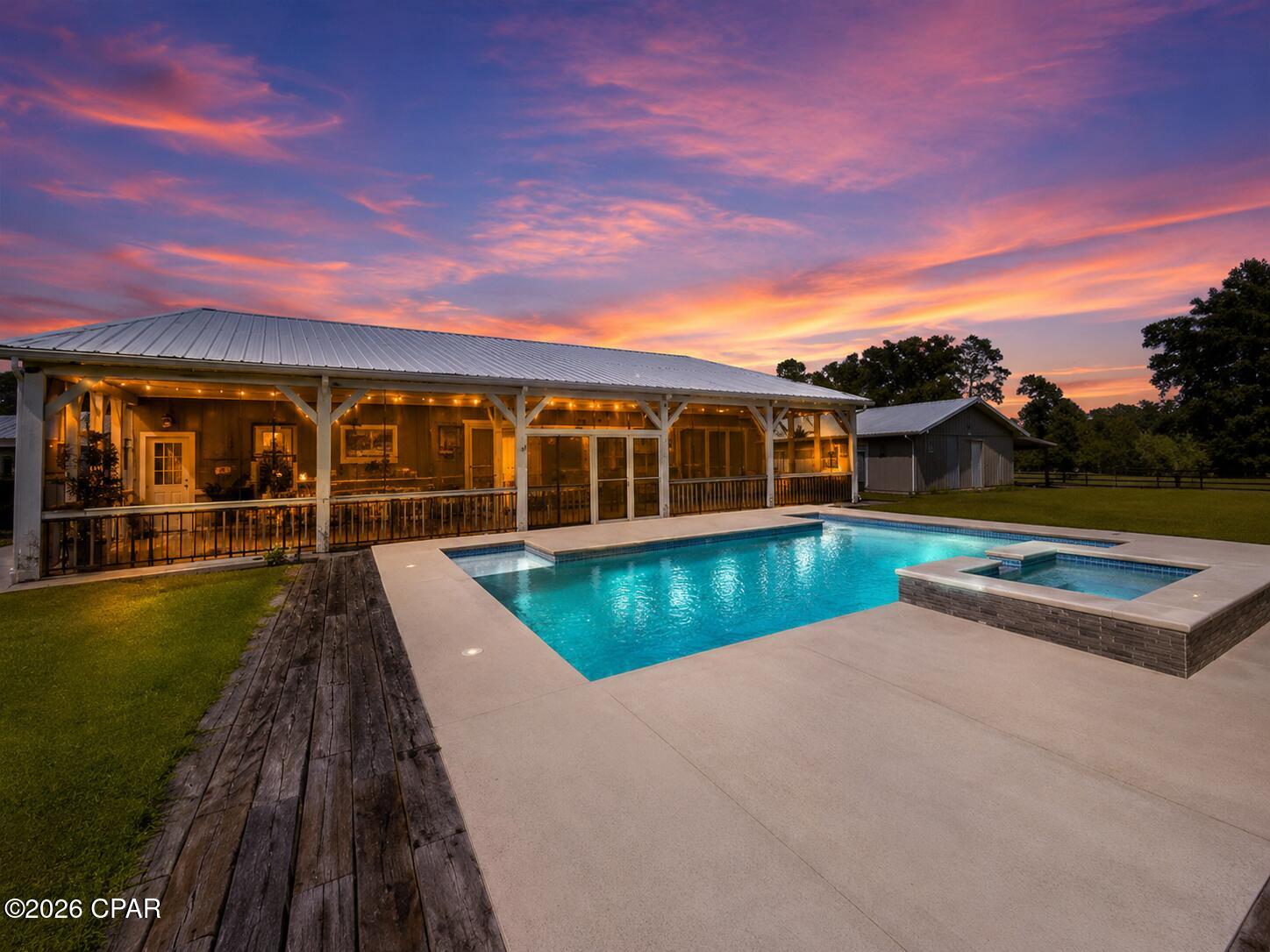 Welcome to a property that truly has it all--country living, incredible outdoor spaces, agricultural potential, and resort-style amenities all in one remarkable setting! This 3-bedroom, 2.5-bath home was designed for both comfortable everyday living and unforgettable entertaining.

Inside, you'll find 10-foot ceilings and tile flooring throughout, along with a huge chef's dream kitchen offering abundant workspace and an attached walk-through pantry. Step outside to what may be the home's best feature--a spectacular 60' x 12' screened porch overlooking the property. With tiled floors, a built-in grill, sink and beverage refrigerator, this is an outdoor living space you'll use year-round. A convenient half bath is accessible directly from the porch, making it perfect for guests enjoying the inground saltwater pool and spa.

Beyond the home, this property is exceptionally well equipped. Horse owners will appreciate the covered barn area with attached enclosed storage and two adjoining cross-fenced pastures. There are also two additional animal enclosures ideal for goats, chickens or other livestock, plus a woodshed.

The property includes an impressive approximately 5-acre Satsuma grove, which the owner reports produces an estimated 20,000-30,000 pounds of fruit annually. The grove is fully irrigated and even has its own dedicated generator.

Need space for equipment, hobbies or projects? There's an enclosed workshop with two roll-up doors and an attached lean-to, providing plenty of room for tools, tractors, ATVs and more.

Even better, the home itself is equipped with a whole-house gas Generac generator, adding another level of convenience and preparedness.

Whether your dream includes horses in the pasture, harvesting your own Satsumas, afternoons by the pool, working in your own shop, or simply sitting on that incredible screened porch taking it all in, this is much more than a home--it's a lifestyle property with possibilities in every direction.