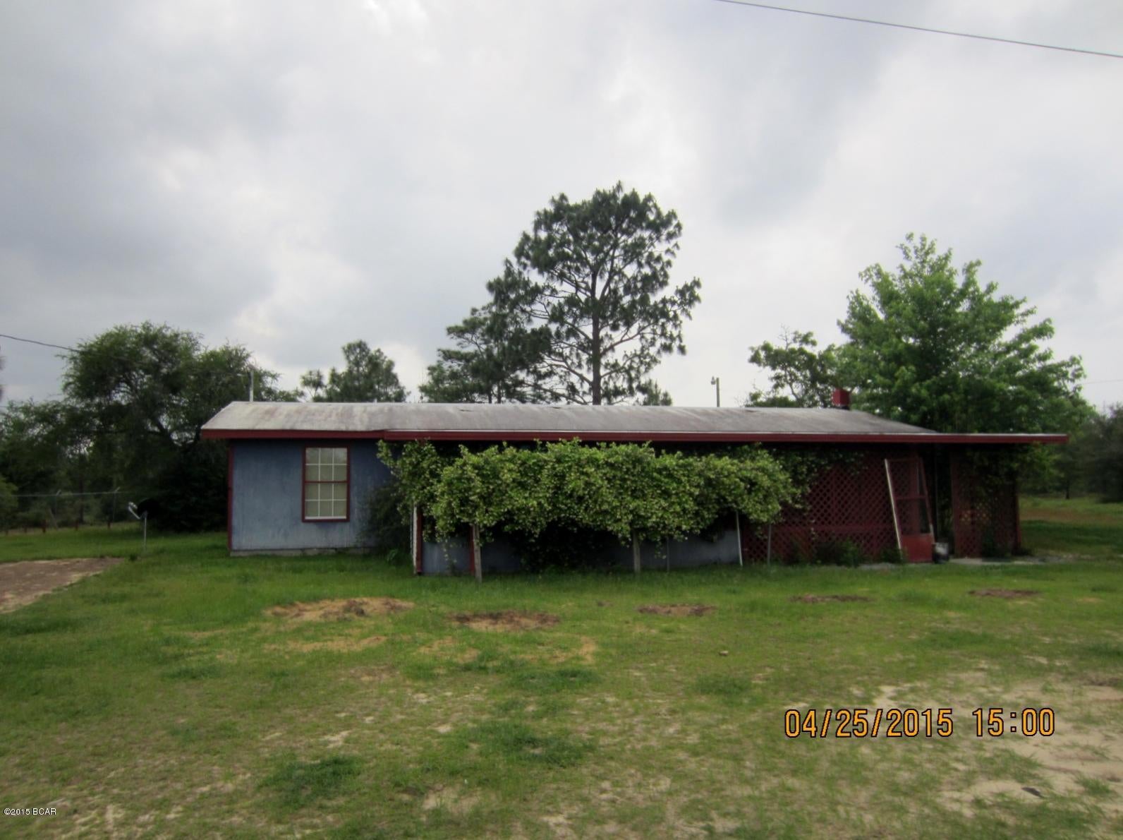 Block home with 6' chain link fence around the immediate yard area and multiple double gates for entry/exit including 2 front entrances and 1 back gate.  The property is a total of 10 acres possibly with an easement in the rear of the property.  Additionall under roof living space includes a covered and enclosed front porch with a sliding door leading into the kitchen/dining area and a covered walkway leading to the covered and enclosed back porch.  Interior features several rooms including 2 bedrooms 1 bath and laundry.  Additional storage building behind the house and within the chain link fenced yard.  Home does have a well on site, central heat and air system, but condition is unknown.  All information is true to best of our ability.