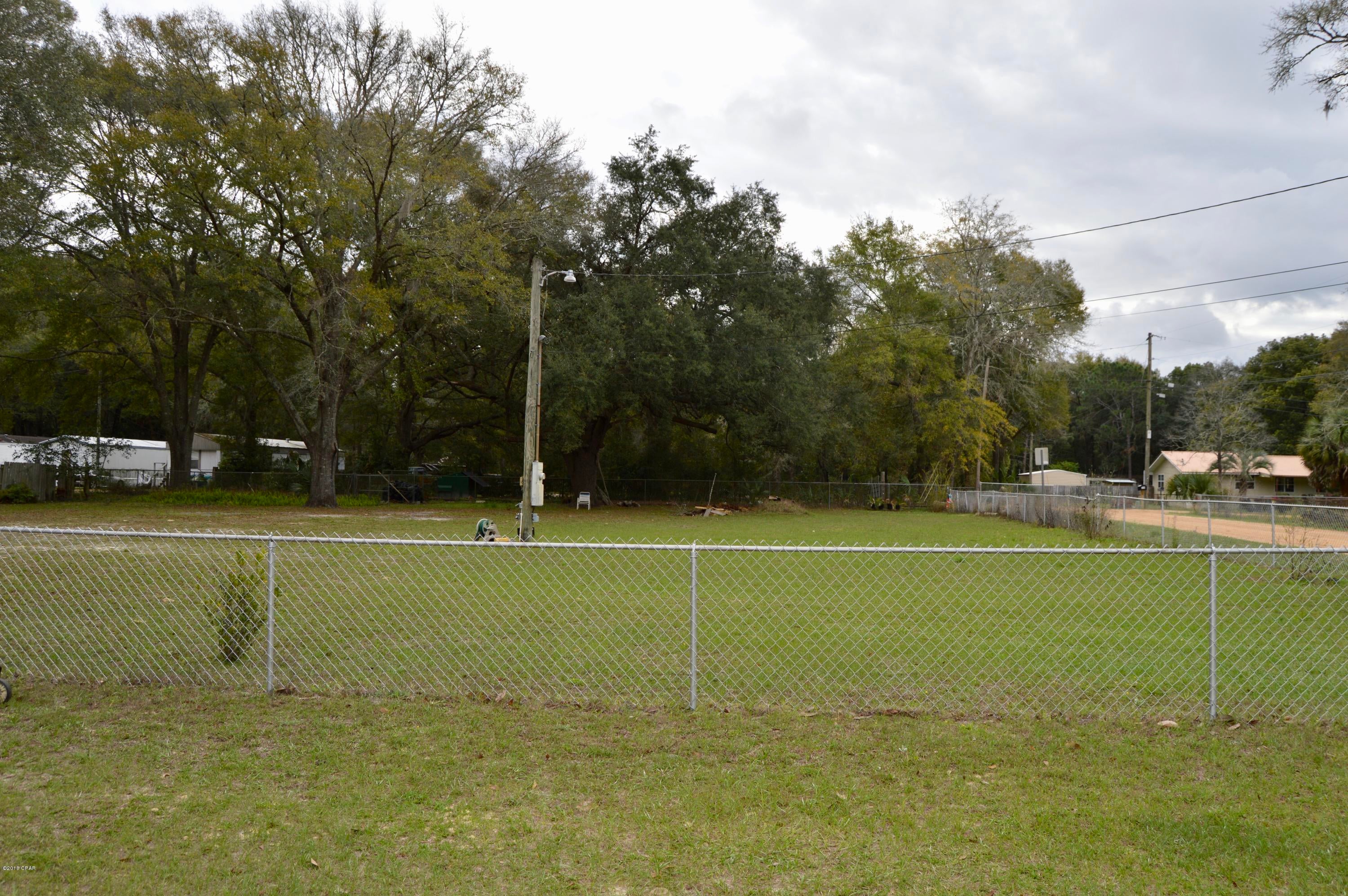 Centrally located  1/2 acre (+-)fenced lot ready to build your dream home! This fenced lot already has septic and power. It just needs a well to make an awesome home site in a great location! Nice flat lot located East of the current home with some great trees and plenty of room. It can be negotiated in the purchase of the home, see MLS # 668775.  The lot will have to be surveyed and split from the current parcel. Measurements are approximate, please verify if important.