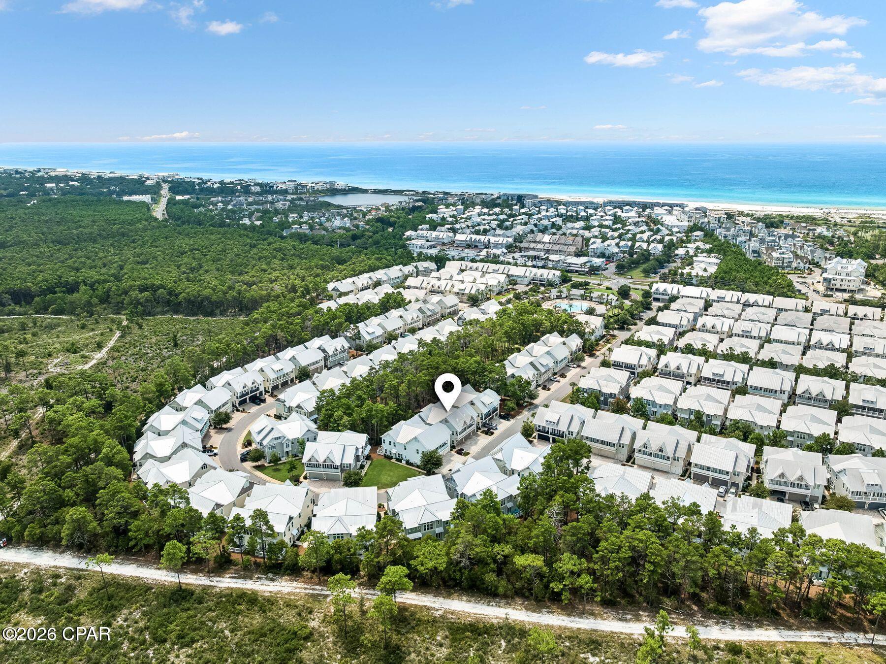 Currently the lowest-priced B unit in Prominence, this upgraded three-bedroom townhome presents a compelling opportunity for buyers seeking value, rental potential and the 30A lifestyle. Offered fully furnished and move-in ready, the home pairs a private wooded backdrop with thoughtful upgrades and rental projections of approximately $75,000 to $100,000 annually, making it equally appealing as an investment property, second home, or full-time coastal residence.

Inside, 10-foot ceilings and an open-concept layout create a light and inviting main living space. Upgraded hardwood floors, custom lighting and shiplap accent walls add warmth and coastal character, while the kitchen features granite countertops, stainless steel appliances, a gas cooktop, generous pantry space and a large island with bar seating. The kitchen flows seamlessly into the dining and living areas, creating plenty of room for family and friends to gather.

Upstairs, the spacious primary suite features a shiplap accent wall and is joined by two additional guest bedrooms and a full hall bath. Behind the home, a wooded green-space buffer provides a peaceful sense of privacy and separation.

A spacious two-car garage offers valuable room for vehicles, bikes, beach gear and storage, while a custom chalkboard wall adds a playful touch for younger guests.

Ideally situated along Scenic Highway 30A between Seaside, Florida, and Rosemary Beach, Prominence offers a resort-style pool, fitness center and convenient access to the area's beaches and bike paths. Just across 30A, The Big Chill offers dining, shopping, live entertainment and family-friendly events in one of the area's favorite gathering places.

With upgraded finishes, a private wooded setting, strong rental potential and the lowest price among B units currently available in Prominence, this property stands out as an exceptional opportunity to own along 30A.