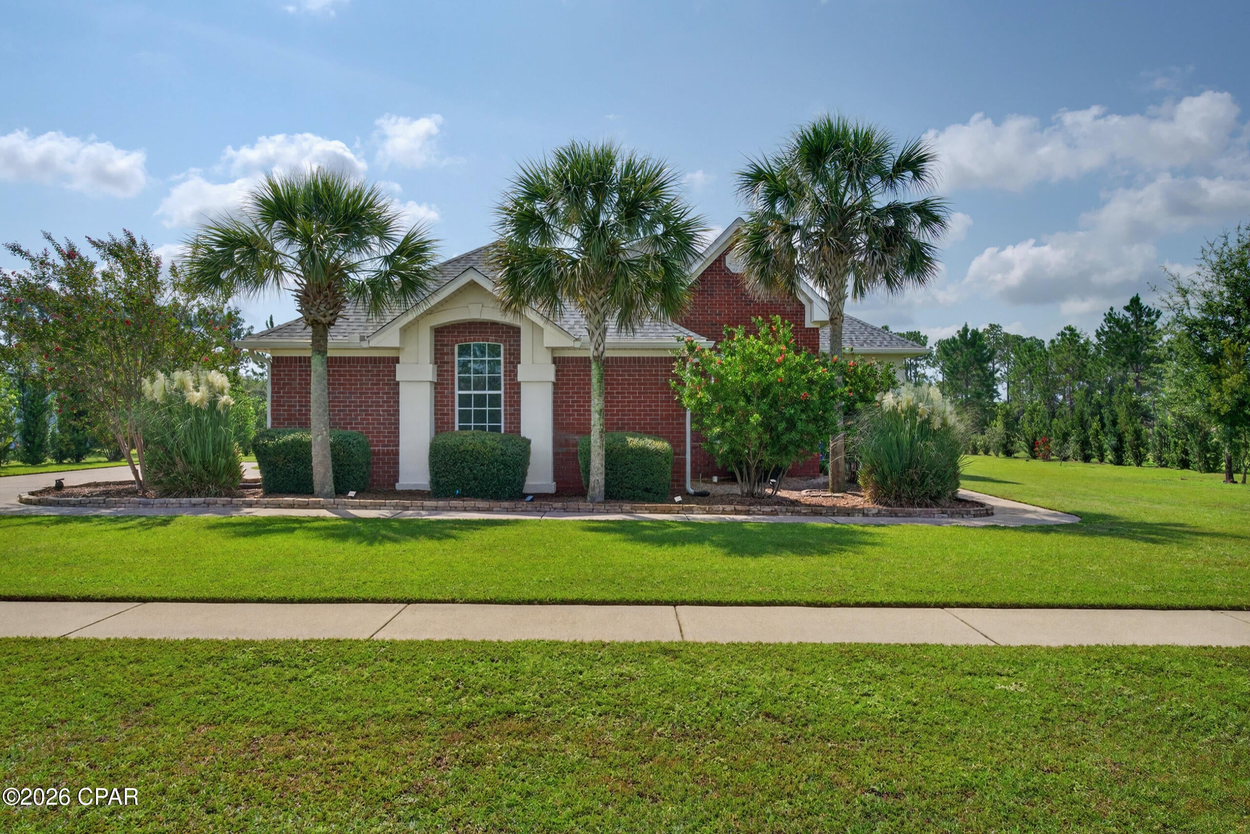 Welcome to 103 Tournament Lane, a beautifully appointed 3-bedroom, 2-bath home offering 2,874 heated and cooled square feet in the gated golf course community of Windswept Estates in Freeport. Situated along the golf course near the 9th tee, this spacious one-story home combines custom details, thoughtful updates, and plenty of room for both everyday living and entertaining. Inside, you'll find expansive 11-foot ceilings throughout the foyer, living room, kitchen, breakfast area, formal dining room, and Florida room, with 9- and 10-foot ceilings in the remaining spaces. Craftsman-style baseboards and crown molding, bullnose-finished sheetrock, plantation blinds, hardwood flooring, tray ceilings, custom cabinetry, and a gas fireplace add character throughout the home. The kitchen features under-cabinet lighting, a large single-basin stainless steel sink, black chrome LG and Samsung appliances, and a gas stove. The spacious primary suite includes a beautifully finished bath with tile and granite, built-in his-and-her clothes hamper drawers, and a coastal-inspired distressed plantation blind. The flexible floor plan also offers the opportunity to create an additional bedroom or an oversized game and entertainment space with room for a pool table. Major improvements include a new roof installed in August 2025, a TRANE HVAC system installed in 2022 with a new TRANE Hyperion air handler added in March 2026, and a water heater replaced in 2021. Outside, enjoy extensive landscaping, an irrigation system supplied by a shallow well and pump, and attractive artist lighting at the front entrance. Windswept Estates offers community amenities including a swimming pool, tennis courts, basketball courts, and golf, all within a gated setting. Located in the growing Freeport area, this home provides small-town living with convenient access to beaches, restaurants, shopping, Destin, Panama City Beach, and Northwest Florida Beaches International Airport.