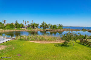 BACK ON MARKET.  Financing issues on buyer side.  
Beautiful double lot on Willow Bay/Gulf access. The lot sets directly across from the T-Box on the 7th hole of Country Club Golf Course and Willow lake. You'll have a view of the bayou in the morning as you drink your coffee on the deck of the new home you've built and of the lake as you pull out of your drive. Kayak, relax, play golf, or eat at the Country club. It's all right there.