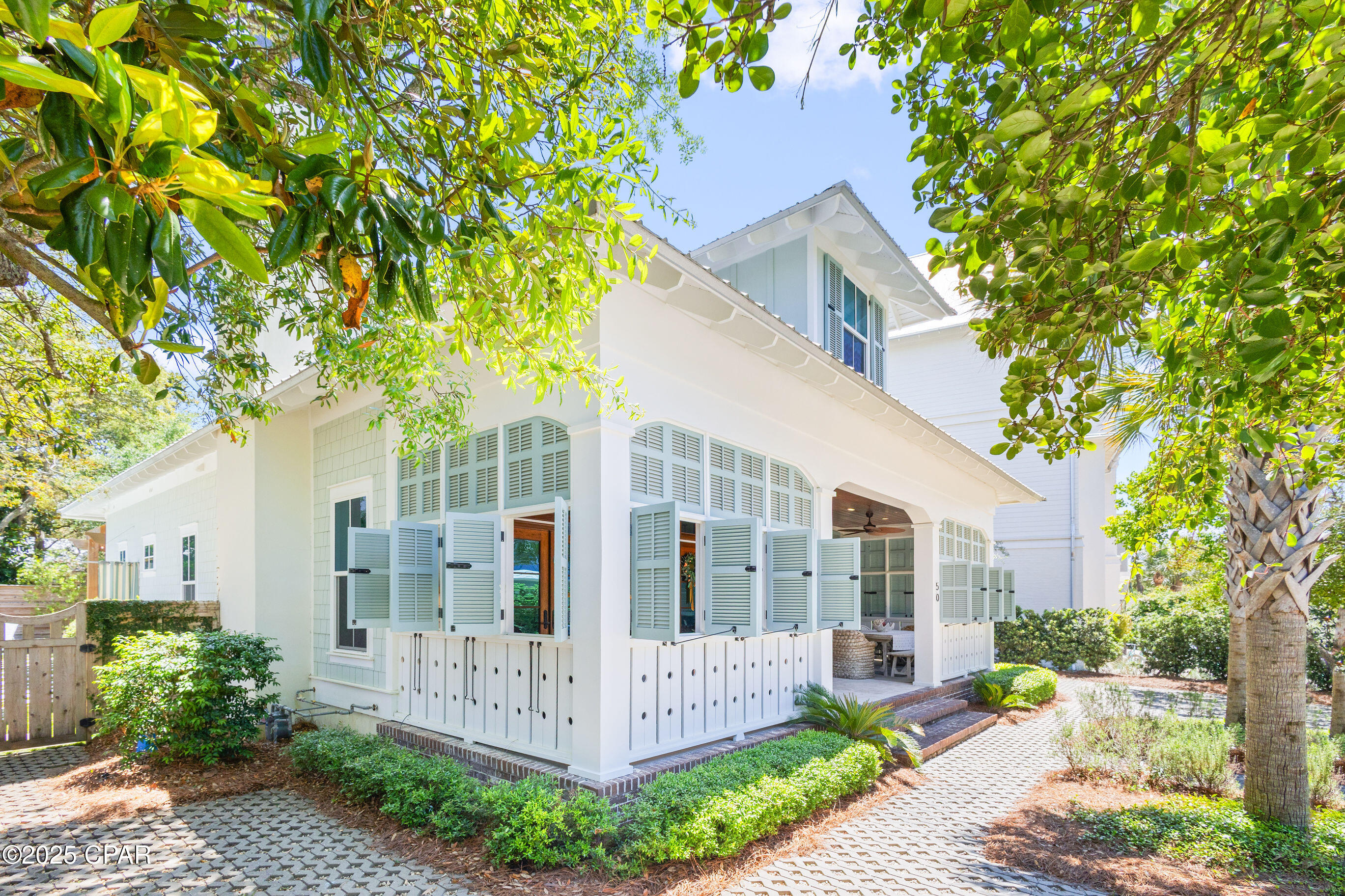 Welcome to 50 Camellia Street — a home where Southern charm meets coastal living in the heart of Old Seagrove Beach, just a bike ride from the energy of Seaside and WaterColor and just steps to the serenity of the Gulf. 

This property is a custom-crafted Southern Living plan, built by renowned 30A builder Mark Bakane. This refined coastal retreat seamlessly blends notes of timeless lowcountry architectural features with relaxed beachside elegance.

From the moment you arrive, the home's craftsmanship is evident. Inviting expansive front porches, natural wood accents and exterior gas lanterns illuminate the exterior beauty of this home. Step onto the storybook front porch where timeless Southern charm meets laid-back coastal luxury. Framed by classic shutters and natural wood elements this space offers a private, breezy retreat perfect for morning coffee or evening cocktails. Tongue-and-groove ceilings, woven seating, and coastal-inspired lighting set the tone for relaxed gatherings with friends and family. Whether you're dining alfresco at the farmhouse-style table or unwinding beneath the ceiling fan with a good book, this inviting porch feels like an extension of the home's heart - warm, welcoming, and wonderfully serene.

Inside, the home opens to a large living space framed by shiplap walls, rich wood flooring, and designer lighting. The gourmet kitchen is a showstopper, outfitted with custom cabinetry, top-tier appliances, marble countertops, and an oversized island made for entertaining.

The floor plan offers multiple living areas, generous guest accommodations on the first and second levels, and a private owner's suite that feels like a true sanctuary with spa-inspired finishes.

Outdoor living is elevated with generous porches and a tranquil backyard space. The backyard is an entertainer's dream, centered around a resort-style pool that exudes luxury. Framed by elegant stone pavers set in lush green turf, the design strikes a perfect balance between sophistication and coastal charm. Ample space for lounging under the sun surrounds the water, while a pergola-covered seating area invites relaxed gatherings or evening cocktails by the pool. Whether you're hosting summer celebrations or enjoying quiet mornings, this thoughtfully curated outdoor oasis elevates everyday living.
