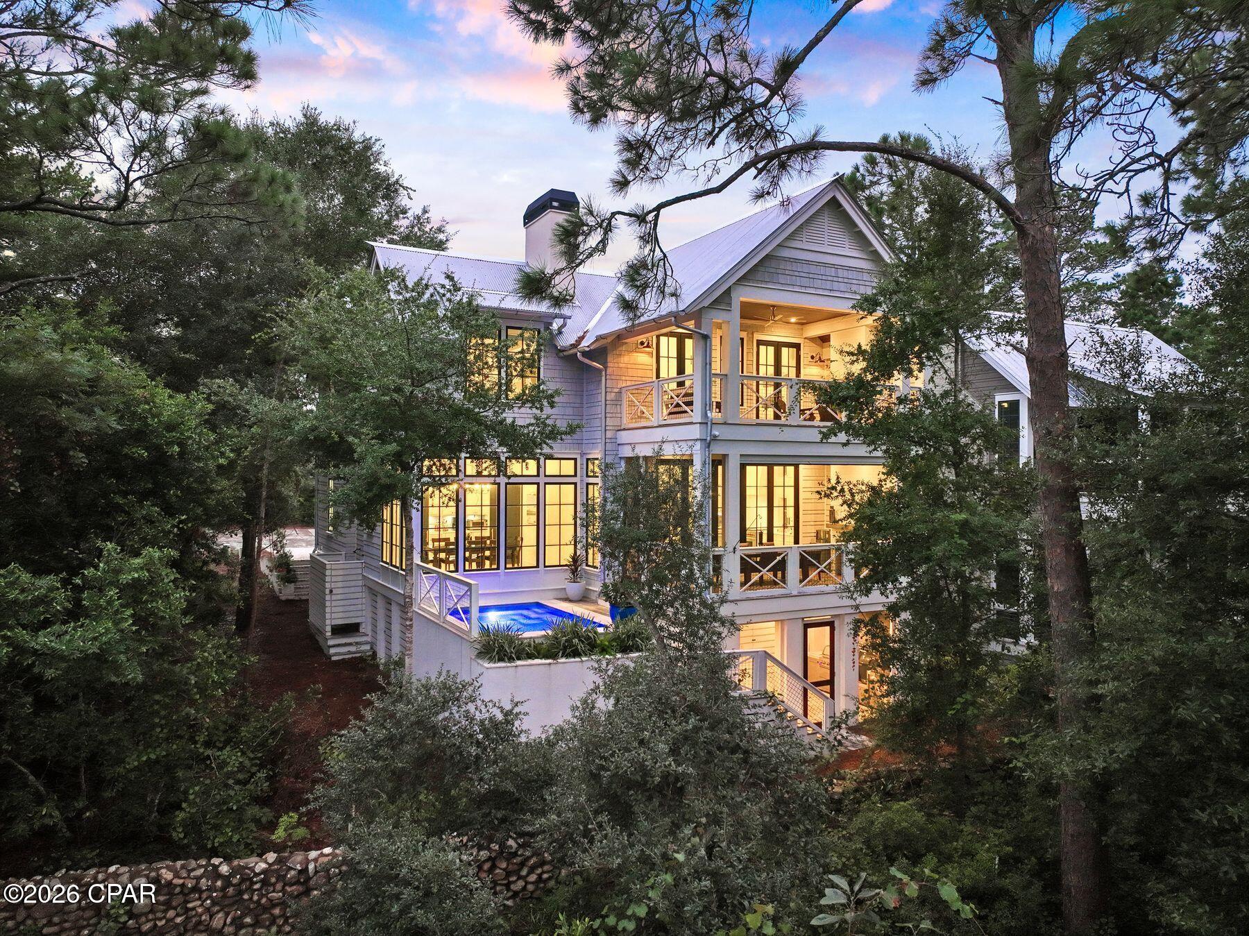 There are only a handful of places in the world where coastal dune lakes exist; even fewer offer the opportunity to live on the shores of one. Here, that rare setting is paired with something equally coveted on Scenic Highway 30A: the privacy of a gated community where short-term rentals are not permitted. With 33 South Branch Road currently the only home available in Draper Lake Coastal Village, opportunities to own within this private enclave are exceptionally limited. Set overlooking Draper Lake, this Geoff Chick-designed residence brings together architecture, water, and nature in an extraordinary setting. Built in 2023, the five-bedroom, four-full-and-two-half bath home spans 3,330 square feet, with lake views woven throughout its indoor and outdoor living spaces. At the heart of the home, a Euro-Wall opens the kitchen and living area to a screened porch overlooking Draper Lake, creating a seamless connection between the interiors and the natural setting. A fireplace and Bromic heater make the porch an inviting gathering space throughout the seasons, while just beyond, the private heated and chilled pool offers beautiful views across the lake. On the level below, a full summer kitchen creates an additional space for outdoor entertaining. The primary suite connects to the landscape, opening to a private porch overlooking the lake. Complete with a fireplace, this secluded retreat offers a peaceful setting framed by the lake's quiet beauty.

Inside, thoughtful craftsmanship and elevated finishes continue throughout, with pecky cypress ceilings, hardwood floors and three fireplaces. The kitchen is designed equally for everyday living and entertaining, anchored by a 48-in. Sub-Zero refrigerator and 48-in. dual-fuel Wolf range, while a butler's pantry with wine cooler provides additional prep and storage space. An oversized one-car garage, smart-home technology, whole-house audio and a generator add another level of comfort and convenience.
Yet what distinguishes this home most is the setting itself. Draper Lake is one of South Walton's rare coastal dune lakes, an internationally rare natural phenomenon found in only a few places worldwide. Here, the lake is not simply a view from the home. It becomes part of daily life. Draper Lake Coastal Village encompasses 40 acres of residences, protected green space and winding trails thoughtfully designed around the lake.
Inspired by Adirondack Great Camps and historic lakefront retreats, and planned by the town planners behind Seaside, Florida, and Rosemary and Alys Beaches, the community offers two boathouses with watercraft storage and lake access, two community pools, and protected pedestrian access along the shoreline. Here, there is no need to choose between lake and beach. The Gulf of Mexico is just moments away, with the private owners' beach cabana near Gulfview Heights Regional Beach Access offering dedicated parking, restrooms and an outdoor shower. Paddle Draper Lake in the morning. Spend the afternoon along the gulf. Return home to the pool, open the Euro-Wall and watch the evening light settle over the water. Rare by nature, private by design, and unlike almost anything else on 30A.