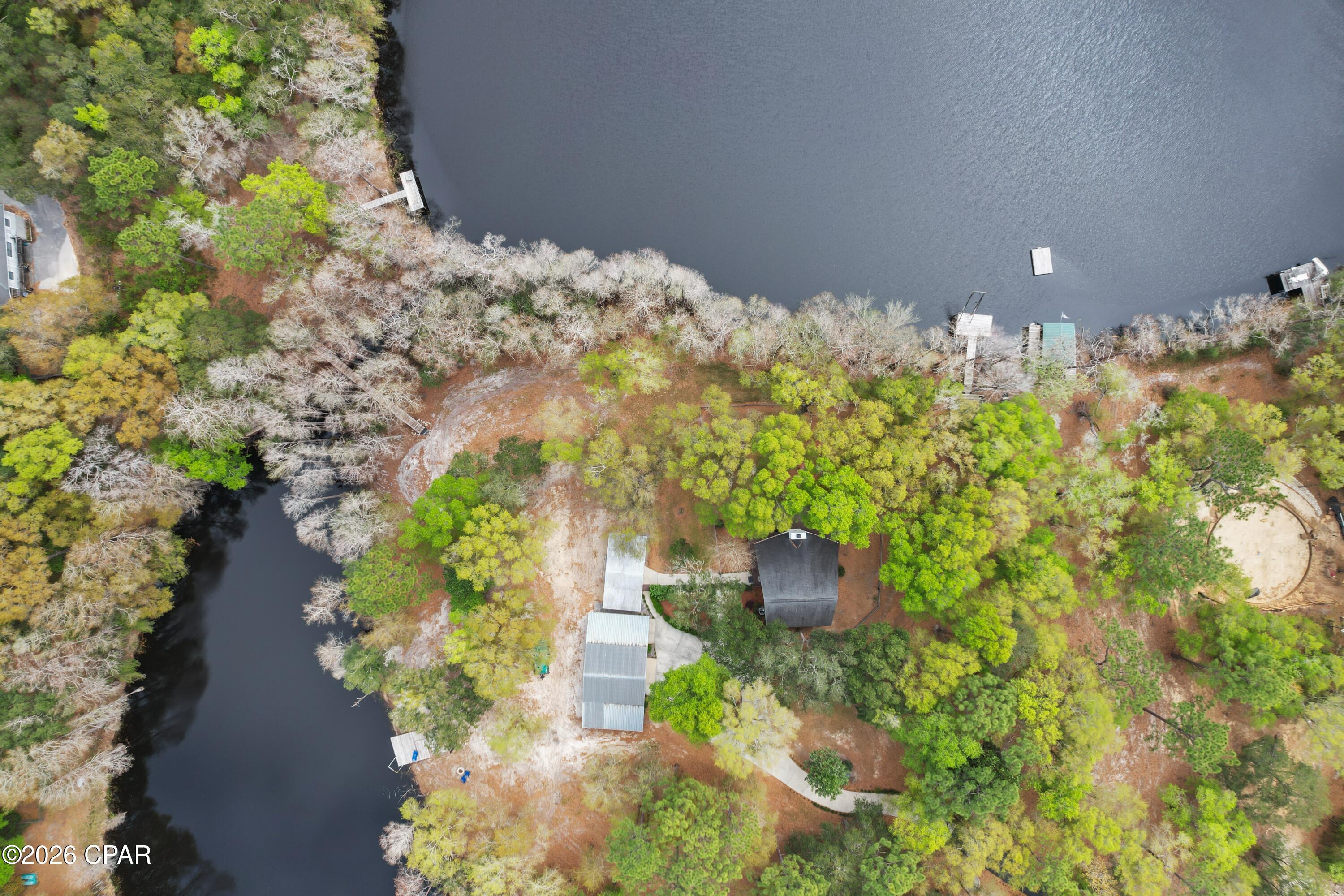 From the moment you enter this property your breath will be taken away with the unbelievable views and well thought out landscaping!
This rare lakefront cottage is nestled on its own peninsula with approximately 1200 feet of water front on Lake Bowen. Lake Bowen is a natural spring fed lake with access to three other surrounding lakes.
A fisherman and duck hunters dream.
With this much water front, this property features not one but five docks. Including a floating dock and a boat house that can hold up to a 20 ft boat. There is a custom Steel bridge that connects both sides of the property. Spend your days jet skiing, fishing, or just enjoying Floridas beautiful nature.
There is also a beautiful Pergola with a gas burning fire pit making that a total of three fire pits on the property. Stepping up to the backside of the home you are warmly welcomed with the very large wraparound deck. You can spend your mornings drinking coffee enjoying the beautiful view and your evenings watching the remarkable sunsets. This two-story cottage was built with concrete filled blocks for durability. Not only is it striking it is also enduring. This home features 1600 ft.² three bedroom two full baths. 
The great room feels warm with 16 foot ceilings and plenty of windows to admire the scenery. 
You literally will feel like you are on vacation! Stepping back outside you will be pleased knowing you have plenty of room to store your vehicles, boats, tractors, or even jet skis with 1,162 sq feet of storage.
There is a deep well for irrigation, so keeping your lawn beautiful all year is easy.
I could go on but you would have to see this property yourself! Definitely one of a kind.
Schedule your showing today! Don't let this opportunity to own your piece of paradise slip away. Approximately 40 minutes away from Panama City Beach.  All information deemed accurate but should be verified by buyer.