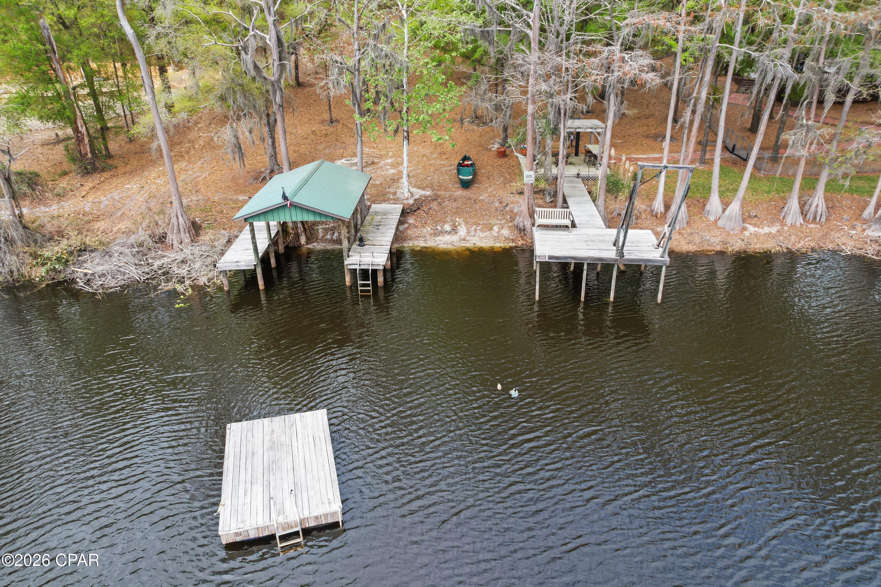 From the moment you enter this property your breath will be taken away with the unbelievable views and well thought out landscaping!
This rare lakefront cottage is nestled on its own peninsula with approximately 1200 feet of water front on Lake Bowen. Lake Bowen is a natural spring fed lake with access to three other surrounding lakes.
A fisherman and duck hunters dream!
With this much water front, this property features not one but five docks! Including a floating dock and a boat house that can hold up to a 20 ft boat! Oh and let's not forget the custom Steel bridge that connects both sides of the property! Spend your days jet skiing, fishing, or just enjoying Floridas beautiful nature.
There is also a beautiful Pergola with a gas burning fire pit making that a total of three fire pits on the property! Stepping up to the backside of the home you're warmly welcomed with the very large wraparound deck! You can spend your mornings drinking coffee enjoying the beautiful view! This two-story cottage was built with concrete filled blocks for durability. Not only is it striking it is also enduring! This home features 1600 ft.² three bedroom two full baths. 
The great room feels great, with 16 foot ceilings and plenty of windows to admire the scenery. 
You literally will feel like you are on vacation! Stepping back outside you will be pleased knowing you have plenty of room to store your vehicles, boats, tractors, or even jet skis with 1,162 sq feet of storage!
There is a deep well for irrigation, so keeping your lawn beautiful all year is easy!
I could go on but you would have to see this property yourself! Definitely one of a kind!
Schedule your showing today! Don't let this opportunity to own your piece of paradise slip away!  Approximately 40 minutes away from Panama City Beach.  All information deemed accurate but should be verified by buyer.