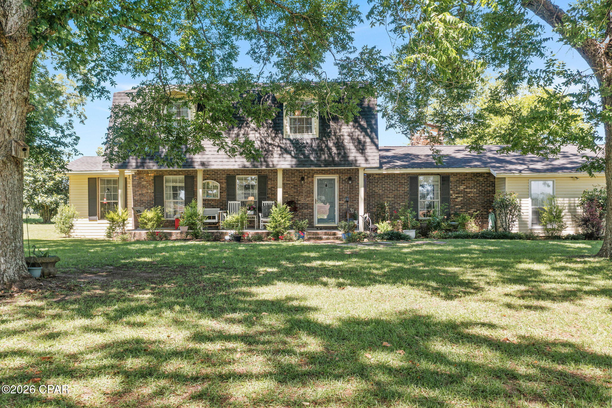Southern Charm on 1.83+/- Acres! Nestled beneath mature shade trees and surrounded by peaceful country scenery, this 3-bedroom, 2.5-bath home offers a timeless design, spacious living areas, and room to enjoy both inside and out. Step inside to find a welcoming floor plan featuring a formal dining room, a dedicated library, and a cozy breakfast area adjoining the kitchen. The spacious living room is highlighted by a gas fireplace, creating the perfect gathering space for family and friends. The primary suite is conveniently located on the main level and features an en-suite bath complete with a jetted tub, separate shower, double vanities, and walk-in closets. Upstairs, you'll find two additional bedrooms, a full bath, and a versatile bonus space that could easily serve as a playroom, media room, home office, or be converted into a fourth bedroom to suit your needs. Outside, the screened porch serves as an extension of the living space, featuring a wood-burning fireplace and peaceful views of the surrounding property. Whether hosting gatherings or enjoying a quiet evening outdoors, this inviting space is sure to be a favorite. A covered front porch adds to the home's Southern charm, while the attached carport provides convenient covered parking. Situated on approximately 1.83 acres, the property provides plenty of space to enjoy outdoor activities, gardening, or simply appreciate the peaceful surroundings. Offering a desirable combination of character, functionality, and country charm, this property is ready to welcome its next owners home.