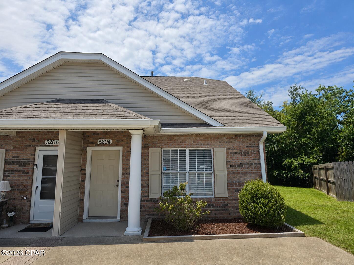 Welcome to 5204 Joshua Lane, a spacious 2-bedroom, 2-bathroom brick townhome offering approximately 1,283 square feet of comfortable living space. Located on a quiet cul-de-sac in Panama City, this home provides convenient access to Tyndall Air Force Base, schools, shopping, restaurants, and nearby water activities.

The living room features a high vaulted ceiling and a cozy gas fireplace, creating an open and inviting central gathering space. Ceramic tile flooring extends through the foyer, dining area, kitchen, and bathrooms. The kitchen offers ample white cabinetry, generous counter space, and essential appliances.

Both bedrooms function as primary suites, with each offering access to a full bathroom. A conveniently located laundry closet includes a washer and dryer.

Outside, enjoy a covered rear porch, an attached exterior storage room, and a spacious privacy-fenced yard. The end-unit location provides additional outdoor space and privacy.

Schedule your showing today and see everything this well-located Panama City townhome has to offer.