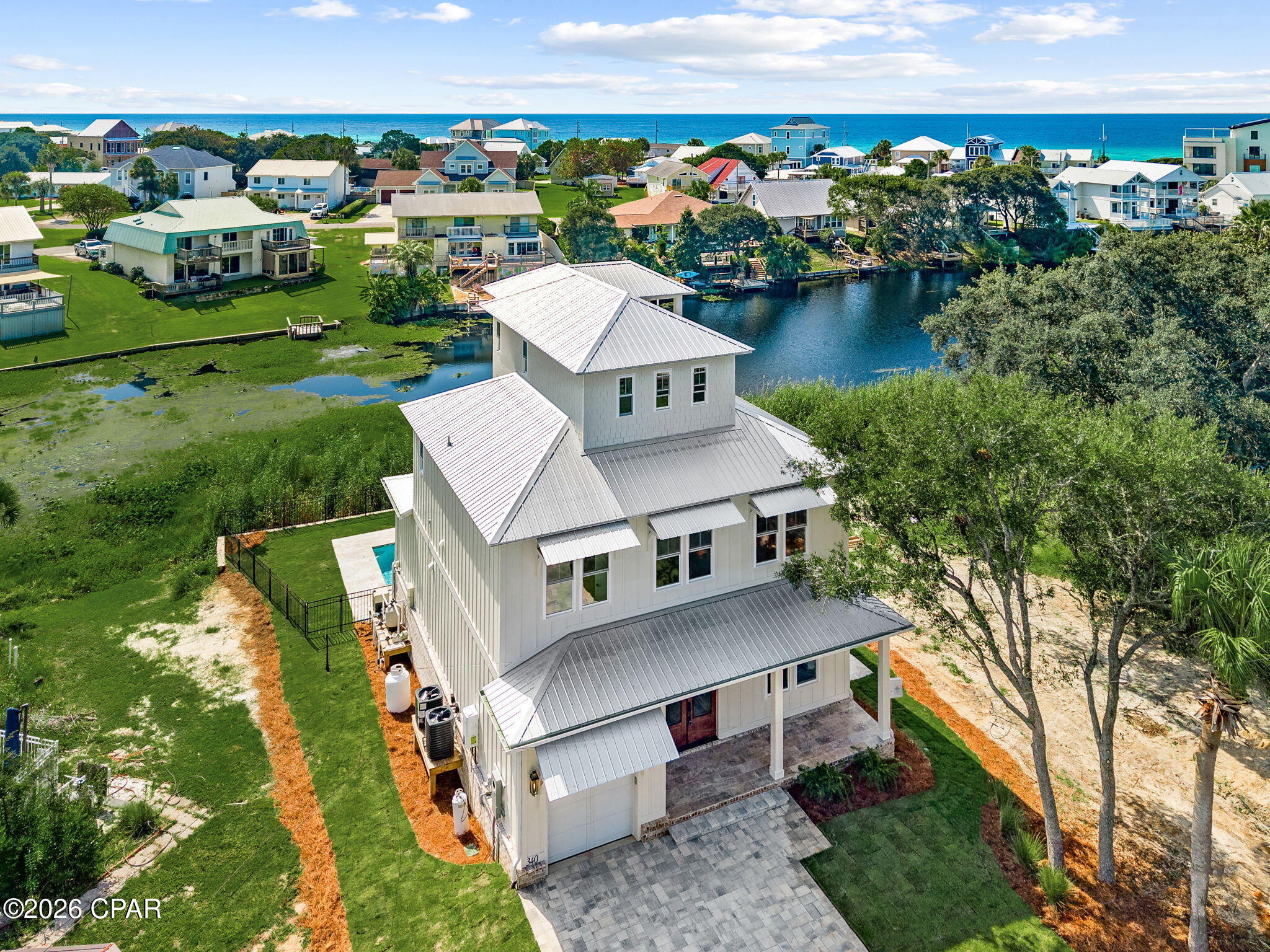 This exceptional, brand-new coastal residence offers a rare opportunity to secure a beautifully designed home just moments from the beach. Thoughtfully planned as a 5-bedroom, 4-bath home, the three-story design blends refined architecture, curated designer selections, and effortless indoor-outdoor living in one of the area's most compelling settings.

Positioned with Riviera Lake just beyond the private pool and Gulf views from the upper levels, the home is designed to capture the beauty of its surroundings from multiple vantage points. The main living spaces are open and inviting, with a spacious kitchen, dining, and living area that flows seamlessly to covered outdoor living. Multiple porches and balconies create a layered coastal lifestyle, ideal for entertaining, unwinding after a day at the beach, or simply taking in the water views. The plans detail 2,815 square feet of living space and about 3,885 square feet under roof, along with a 24' x 12' pool, garage, and a flexible third floor with full bath that can function as the fifth bedroom, a game room, or a living space, all with gorgeous lake and gulf views.

Located approximately 1,000 feet from the beach, this home offers the convenience of beach lifestyle paired with the privacy and visual appeal of a lakefront setting.

Sophisticated yet relaxed, polished yet personal, 340 Le Grand Drive is ideal for the buyer seeking a luxury coastal retreat with designer character, strong visual presence, and a double waterview that most people only dream of.