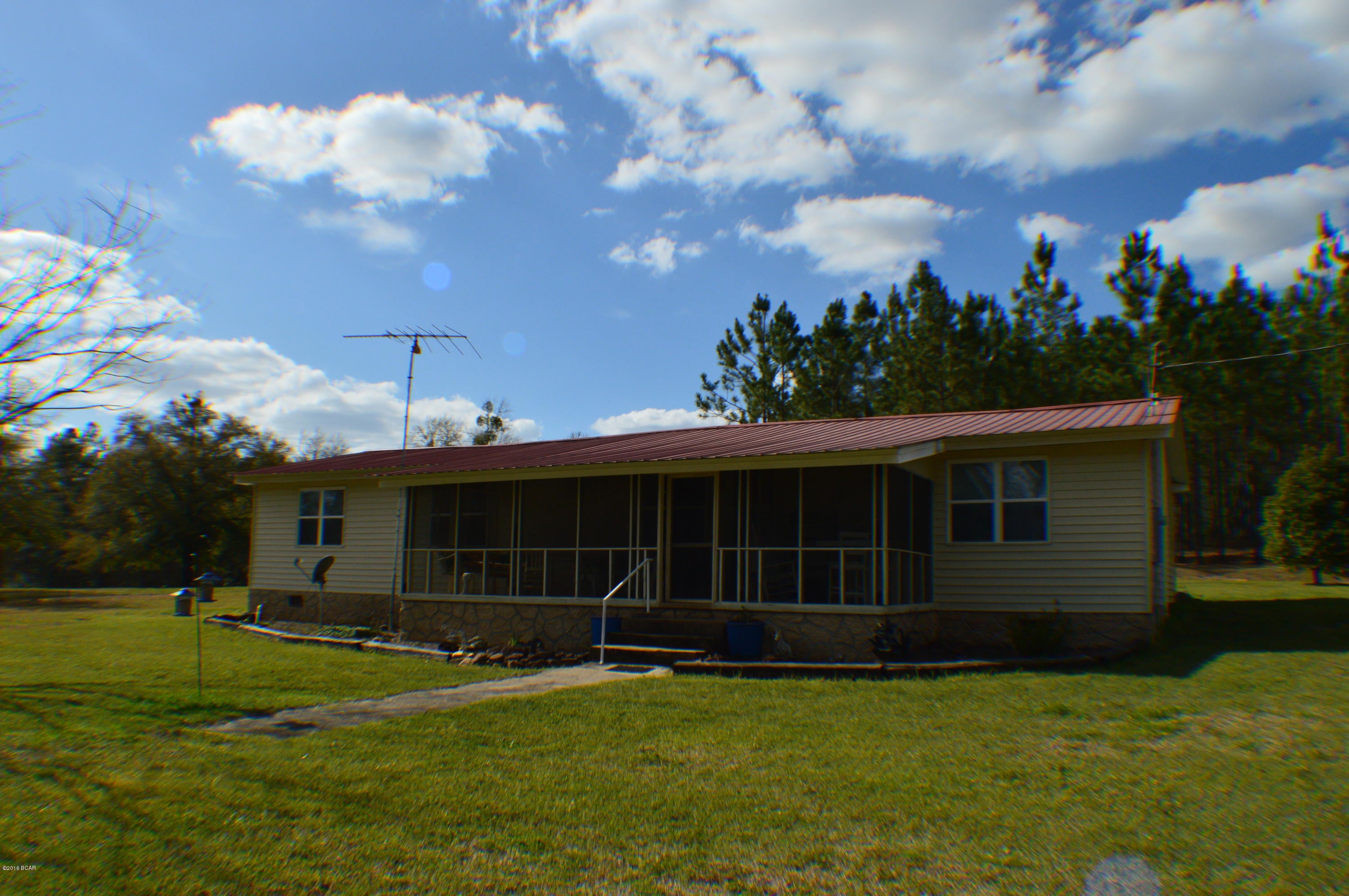 57.25 +/- acres of pure paradise!  This home is truly a one of a kind property and a rare find!  Some of the exclusive features of this property include:  57.25 +/- acres (acreage  negotiable)with 10 +/- acres in pasture that is completely fenced, private access to a 10 acre fish pond, 40 +/- acres in planted pines, 40 x 60 pole barn w/20 x 60 addition which has 25 x 40 workshop w/concrete floor, water & electricity. Home has recently been updated throughout!  This property and acreage is full of wildlife including, deer, and other game not to mention fish in your own pond!  Property is convenient to I10 or Panama City. To fully appreciate ALL the features of this property .. make an appointment today to preview it! ** Dimensions is estimated and will need survey to get exact dimensions **
