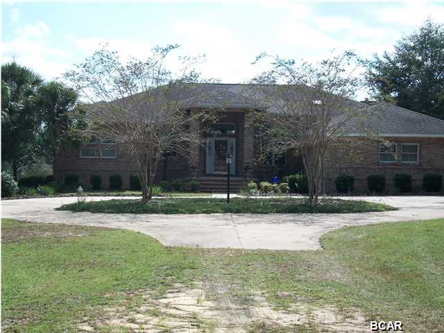 Bring your horses! Quiet country living just minutes away from Lynn Haven. Custom built 3br/3ba home sited on 39+ acres with a pond, is just north of hwy 20 off hwy 77. As you enter the property off Rolling Pines Rd you are immediately enveloped by a dense stand of fragrant pines. The home sits on the top of a ridge overlooking the trees and pond below. As you enter the home the first thing you notice are the 12 ft ceilings, Pella windows (triple paned windows are in the family room and all exterior doors) and the glowing wood flooring. This wood flooring is accompanied by tile in the kitchen area and carpet in the bedrooms. The kitchen boasts a breakfast bar that looks out over the rear of the house. The kitchen features high end appliances as well as a european hood vent over the  glass stove top. Off the kitchen is a homey den with a wood burning stove/fireplace. On the other side of the kitchen is the sunken Living Room with 12 foot ceilings. There is also a home office with custom built cabinetry. It will be great for a computer area or as a place to run a complete home business. The master bedroom is huge with windows looking out onto the woods beyond. The master bath features a garden tub as well as a separate ceramic tiled shower with dual shower heads. Other features include a new roof installed in June of 2014, a 3 car garage, surround sound throughout the entire home, 6'' exterior walls with blown and compacted cellulose insulation, attic R-32 rated cellulose insulation and a 12 zone lawn sprinkler system. Next to the home sits a 20x24 workshop with a roll up garage door. This workshop area is cooled by a window unit and has the plumbing built in but not yet attached. Roughly 3 acres is currently landscaped surrounding the house. The pond is just down the hill and ready for your fishing rod. The property is also home to numerous deer, turkey and ducks. There are roads and trails cut through the entire property. Adjacent to the property is 38,000 acres owned by the Northwest Florida Water Management District that is an unspoiled conservation area. This one is definitely worth the drive!