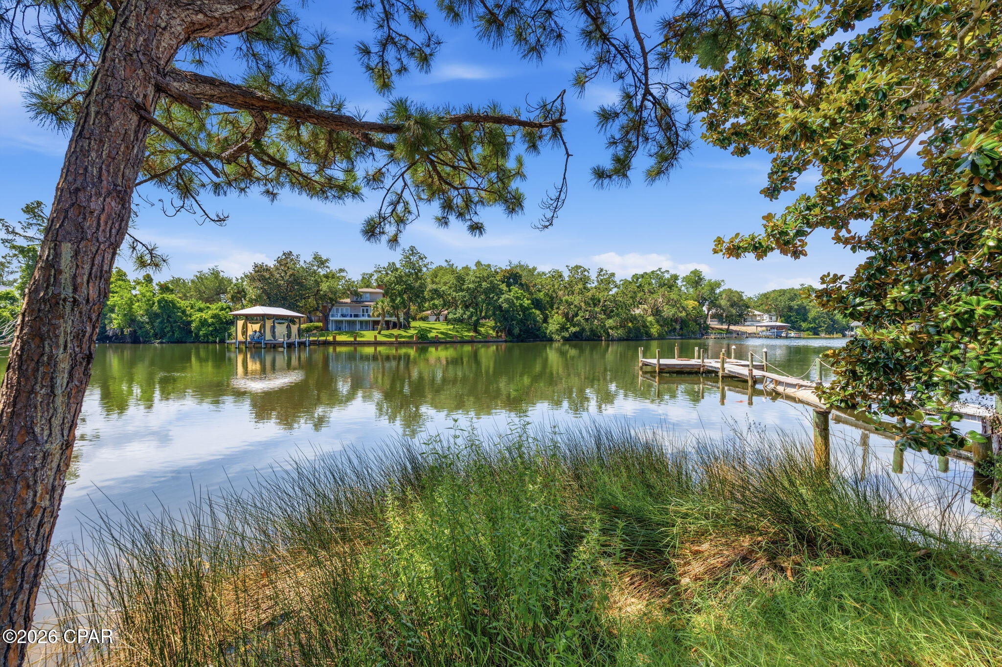 Rare opportunity in St. Andrews! This fully remodeled three-bedroom, two-bath home is being sold with a separate waterfront parcel on Lake Huntington, located approximately 300 feet from the residence. The list price includes both properties, and they must be sold together.

The home features luxury vinyl plank flooring, recessed lighting, updated fixtures, and an easy flow between the living room, kitchen, and dining area. The remodeled kitchen offers white shaker-style cabinetry, solid-surface countertops, stainless steel appliances, a gas range, and an adjoining coffee or beverage station. The oversized primary suite includes a private bath and a large closet with a built-in organization system. Additional features include two guest bedrooms, an updated guest bath, a spacious laundry room with a folding counter and storage, updated windows, modern ceiling fans, and a tankless water heater.

Outside, the large fenced lot provides a gated driveway, abundant parking for a boat or trailer, patio space, and an above-ground pool. The separate 0.064-acre waterfront parcel measures approximately 50 by 75 feet and offers roughly 50 feet of frontage on Lake Huntington. The waterway provides access toward St. Andrews Bay and creates a private setting for fishing, kayaking, watching the sunset, or potentially adding a dock or boat lift. No dock or boat lift is currently installed. Buyers should verify water depth, navigability, boundaries, and permitting requirements for their intended use.

Short-term rental use is permitted at the residence, subject to obtaining all required licenses, registrations, and approvals. The home is also within walking distance of Historic St. Andrews, locally owned restaurants, waterfront parks, shopping, entertainment, and the St. Andrews Marina. This property offers a rare combination of a remodeled home, short-term rental potential, boat parking, a walkable St. Andrews location, and nearby privately owned waterfront. All measurements and information should be verified by the buyer if important.
