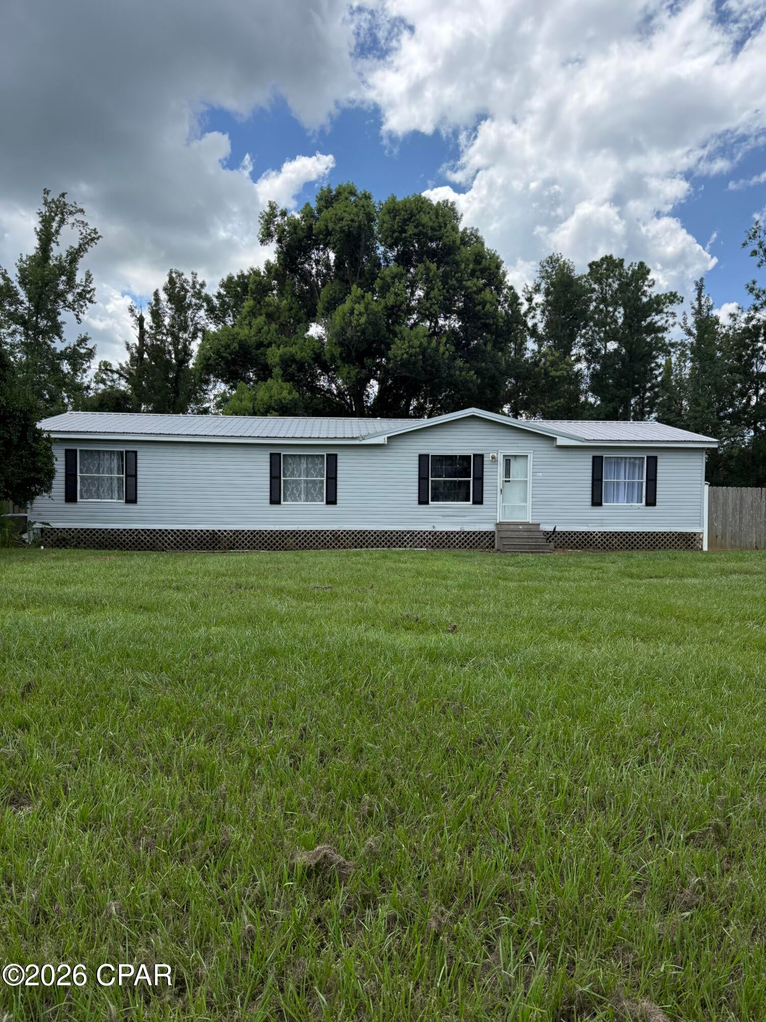 Welcome to a beautifully refreshed home offering the space, privacy and value you've been looking for. Situated on a generous 0.73-acre lot, this 3 bedroom, 2 bath home provides plenty of room to spread out while still being conveniently located near downtown Wewahitchka. Inside, you'll find approximately 1,440 square feet of comfortable living space with updated flooring and a refreshed primary bathroom. The home offers a practical layout with three bedrooms and two full bathrooms, making it an excellent option for a first-time homebuyer, growing household, or anyone looking for more land without sacrificing convenience. Step outside to enjoy a fully fenced backyard with plenty of room for pets, outdoor entertaining, gardening, recreation or simply enjoying your own private space. A durable metal roof adds additional peace of mind for the next owner. Located just minutes from downtown Wewahitchka and approximately 30 minutes from Mexico Beach, this property offers a great balance of small town living and easy access to the Gulf Coast. If you're looking for a move in ready home with a large lot and room to make it your own, this one is worth a look!