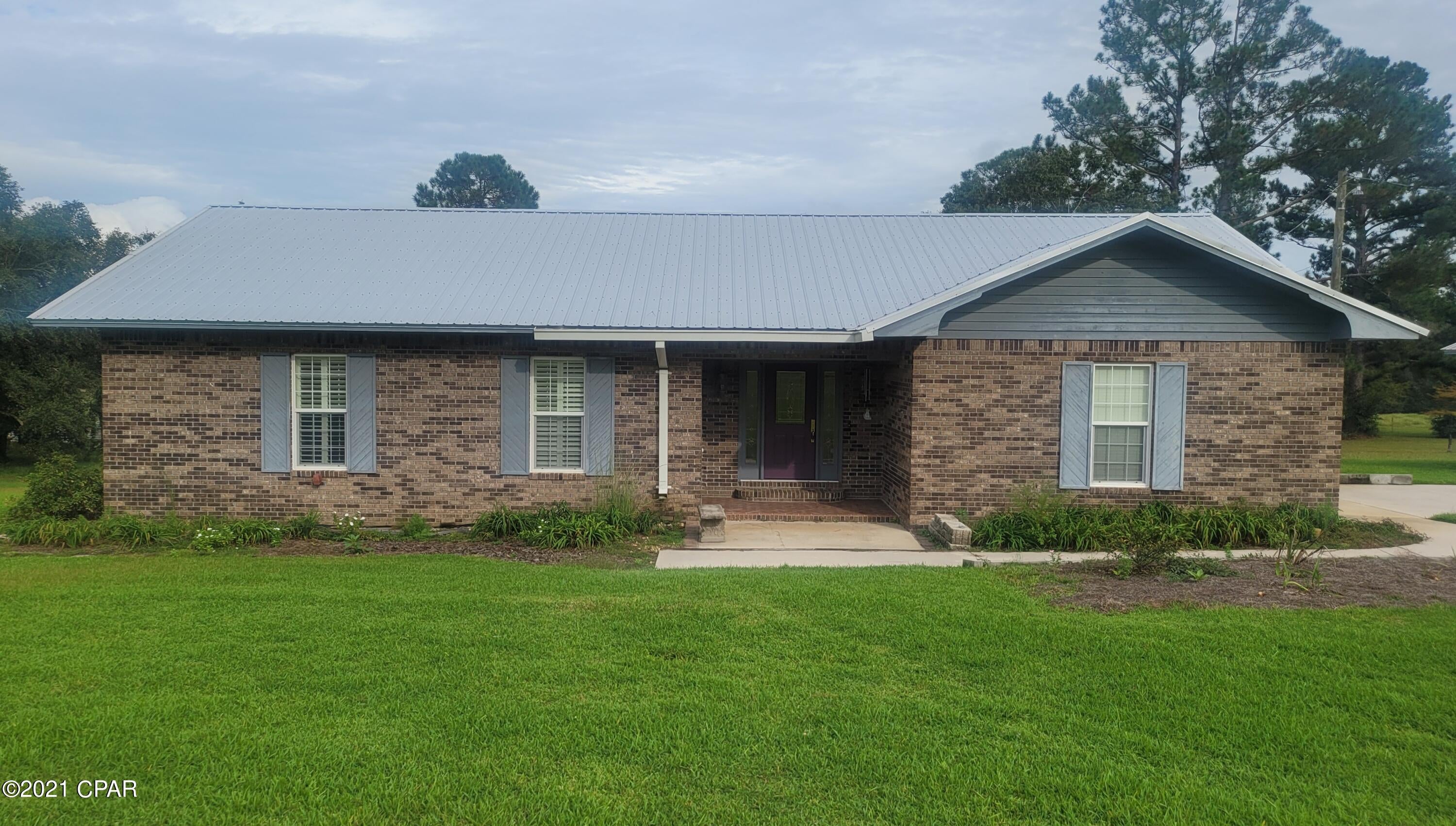 CURRENTLY UNDER CONTRACT, SELLER ACCEPTING BACKUP OFFERS. Great location with this 3/2 brick home on 2.4+/- acres. Home offers a spacious floorplan. Kitchen and dining area, living room with wood burning fireplace. Foyer. Master bedroom with a master bathroom, walk in closet. 2 large additional bedrooms. Full bath in hall. Newer metal roof. Attached garage. Outbuilding for additional storage. Not far from town for shopping and medical facilities. Approx. 45 minutes from Panama City Beaches. This well maintained home is a must see!