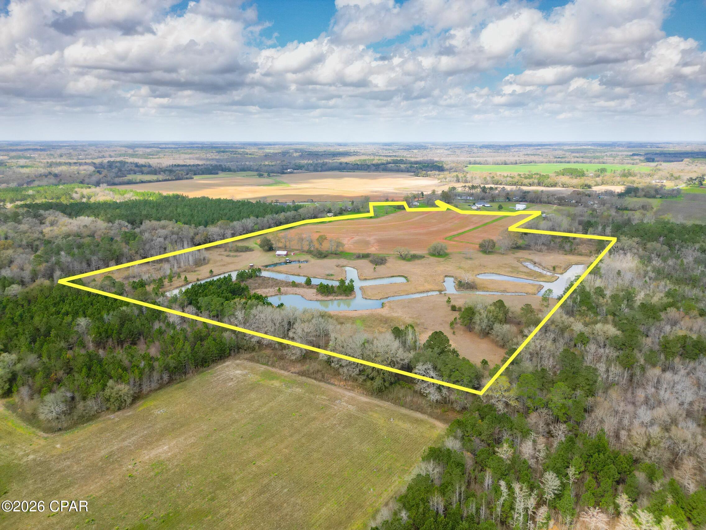 Discover the perfect blend of productive farmland and outdoor recreation with this expansive farm/ranch property. Approximately half of the acreage is currently under a farm lease producing cotton and peanuts, while the other half is ideal for fishing, hunting, and enjoying the outdoors.

The property features two ponds, including a large pond and a smaller pond with a dock equipped with water and electricity, perfect for relaxing or casting a line. Overlooking the ponds is a 1,200 sq ft red enclosed pole barn with a porch, perfect for relaxing and taking in the view.  The pole barn sits on a concrete foundation and includes a kitchen area, ceiling fans and an on-demand water heater, making it a great space for family gatherings, a weekend getaway, or a private fish camp.

With two access points along Hwy 77, plus a well, electricity, and a recent survey already completed, this property offers excellent potential for farming, recreation, or both.