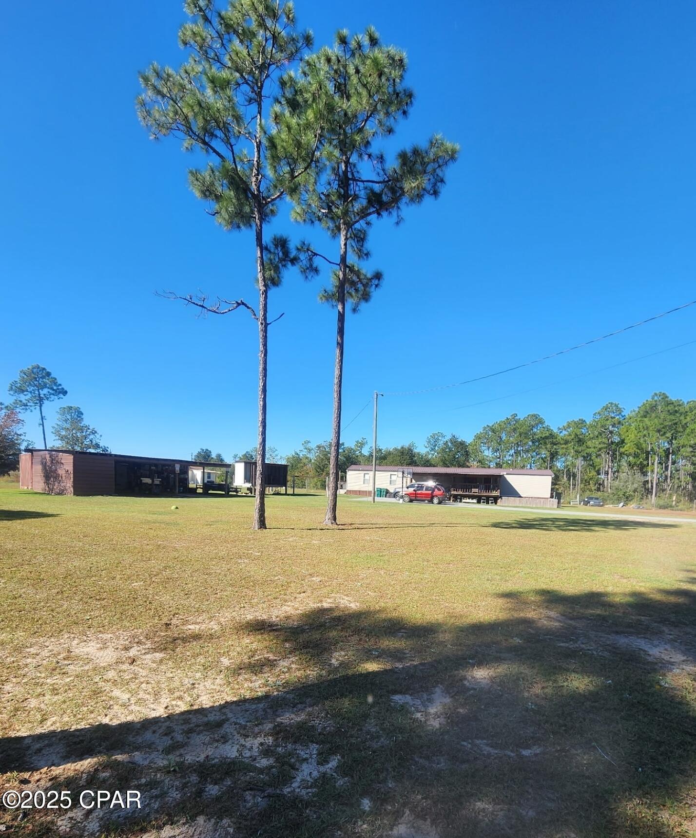 Nice Country Setting with this 2/2 swmh on 1.2 +/- acres. This spacious home offers an open kitchen, dining area, and living room. Split floorplan with master bedroom and master bath on one end and 1 additional bedroom and full bath on other end. There is an additional oversized room currently used as a play room but could also be a 3rd bedroom , family room or whatever extra space you need. It could also be 4 bedrooms if room is divided. Outside you will find a covered deck and above ground pool, perfect for those hot summer days. Additional covered storage with a strapped down metal container currently used as a storm shelter and plenty of room for your lawn mower and tools. Newer roof. Security system. Approx. 20 minutes to town for local shopping and 45 minutes to Panama City Beach.