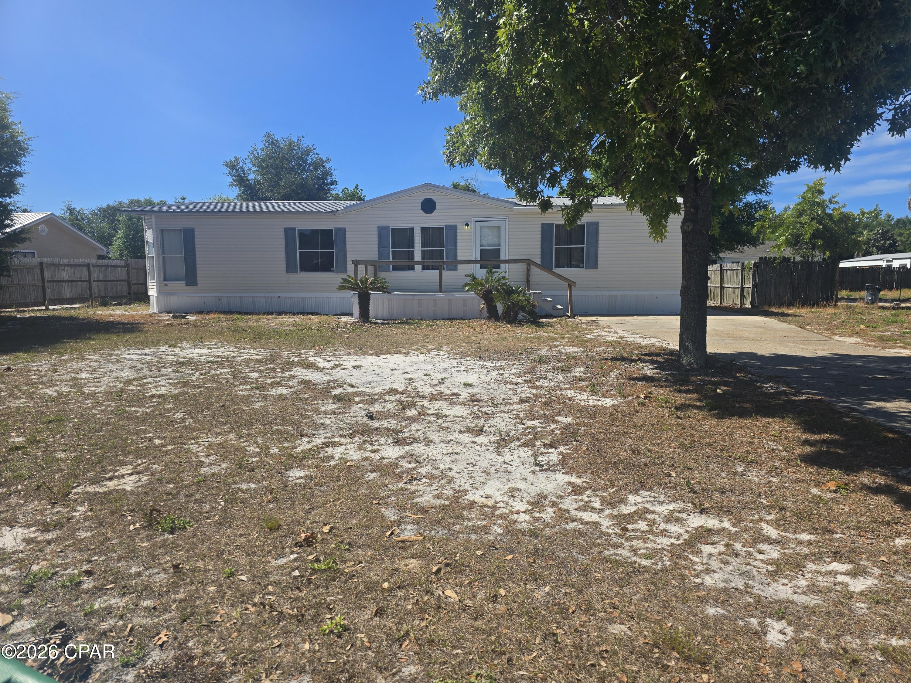 UNDER CONTRACT TAKING BACKUPS GREAT opportunity to own in a quiet neighborhood which is short term rental friendly just minutes from the white sandy beaches!  This spacious manufactured home has a very roomy open floorplan with lots of large windows for an open and airy feel.  The large  living room features a fireplace that can also be seen from the kitchen.  The breakfast bar is finished with decorative glass door cabinets with a spacious kitchen that allows for a pleasant entertaining space.  ALL 3 bedrooms have walk in closets and the large master bedroom ensuite bath has a large soaking tub.  There is a large 10X10' utility room that is accessable from the laundry room. The 18'x10' covered lanai offers even more entertaining space.  Put this property on your must see list!