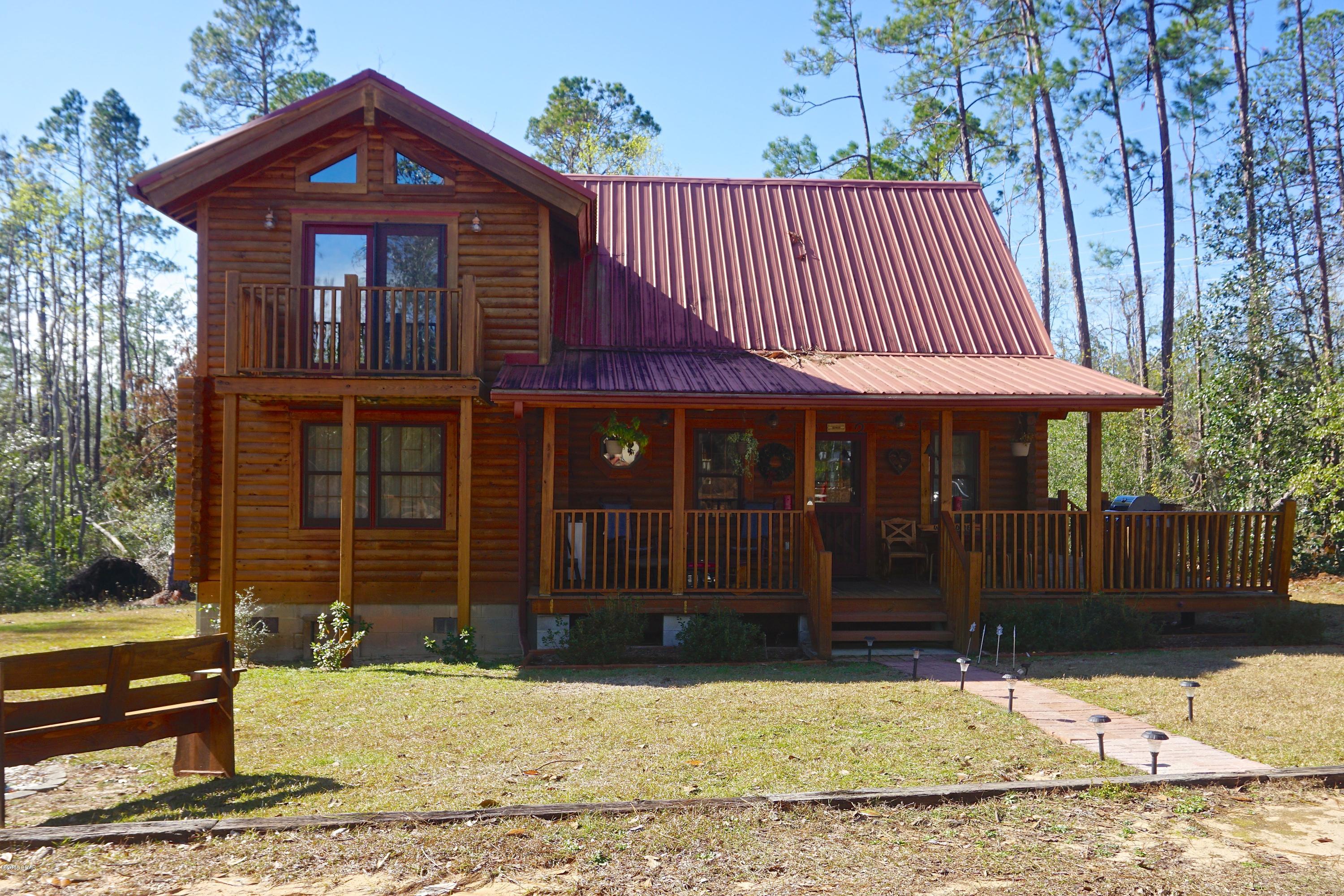 Stunning custom built Australian Cypress log cabin located in Compass Lake in the Hills. This unique home has 2 large bedrooms, each w/ private bathrooms, & good storage. In addition, there is a loft area that would be perfect for an office, hobby area, or guests. It overlooks the floor to ceiling windows in main area, & downstairs living room. Enjoy the open concept living w/ doors to outside porch on 2 sides; perfect for enjoying this private setting w/ creek running along back & fenced gardening area for vegetables or flowers. It is so peaceful here! Home also boasts a fire pit area, 2 storage sheds, & matching log cabin mailbox! The windows are all tinted to lower electric bills, there is an additional auxillary heater downstairs, gas stove, added insulation, & seller has a survey.