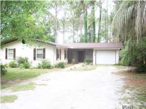 NOTE: NEW ROOF BEING PUT ON FIRST WEEK OF JULY. There is no other place on the beach or in town where I know you can get a 1 acre residential lot in a restricted subdivision on a paved street. This home is ideally located right across from the Navy Base and is only 5-minutes to either the beach or town. This 3-bedroom, 2-bath ranch style home sits on a 1.11 Acre lot and is entirely fenced. The home needs some updating but is of sound construction, stucco over block and is ready for a new family. There is a 1-car garage and a large utility room. The living room features a brick fireplace an a whole wall of custom built in shelving and mantle. There is plenty of room for gardens, a pool, and the subdivision even allows horses. Lots of shade trees add to your privacy. Make an appointment